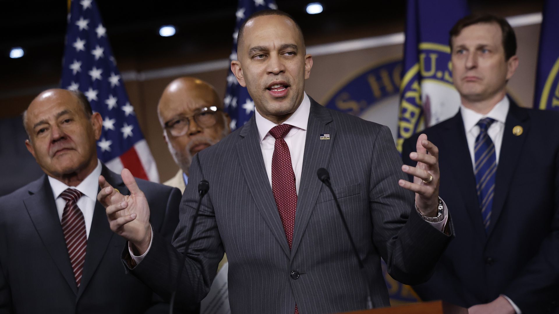 Hakeem Jeffries at a press briefing room flanked by several Democratic colleagues.