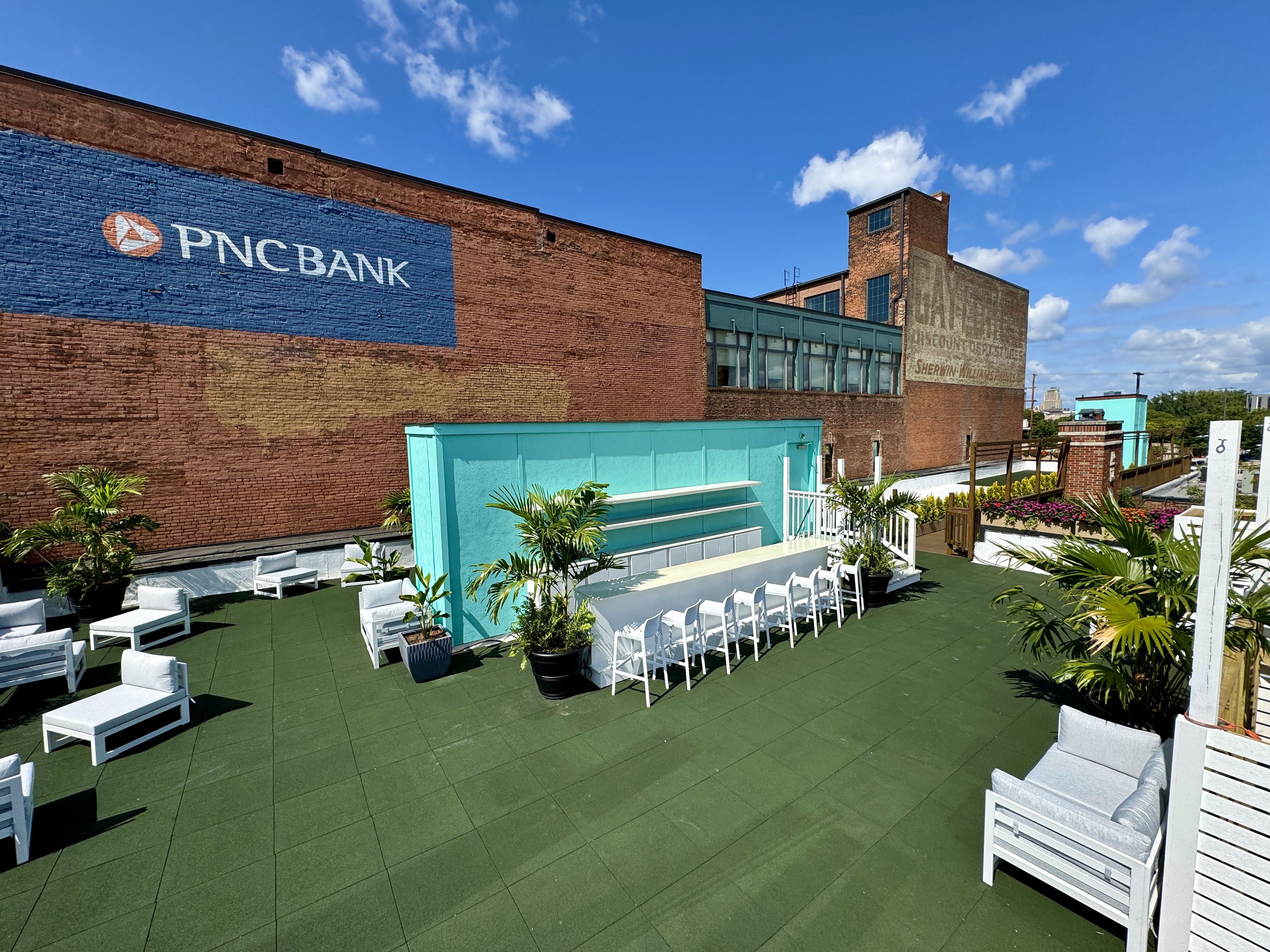 A rooftop patio bar with green floor