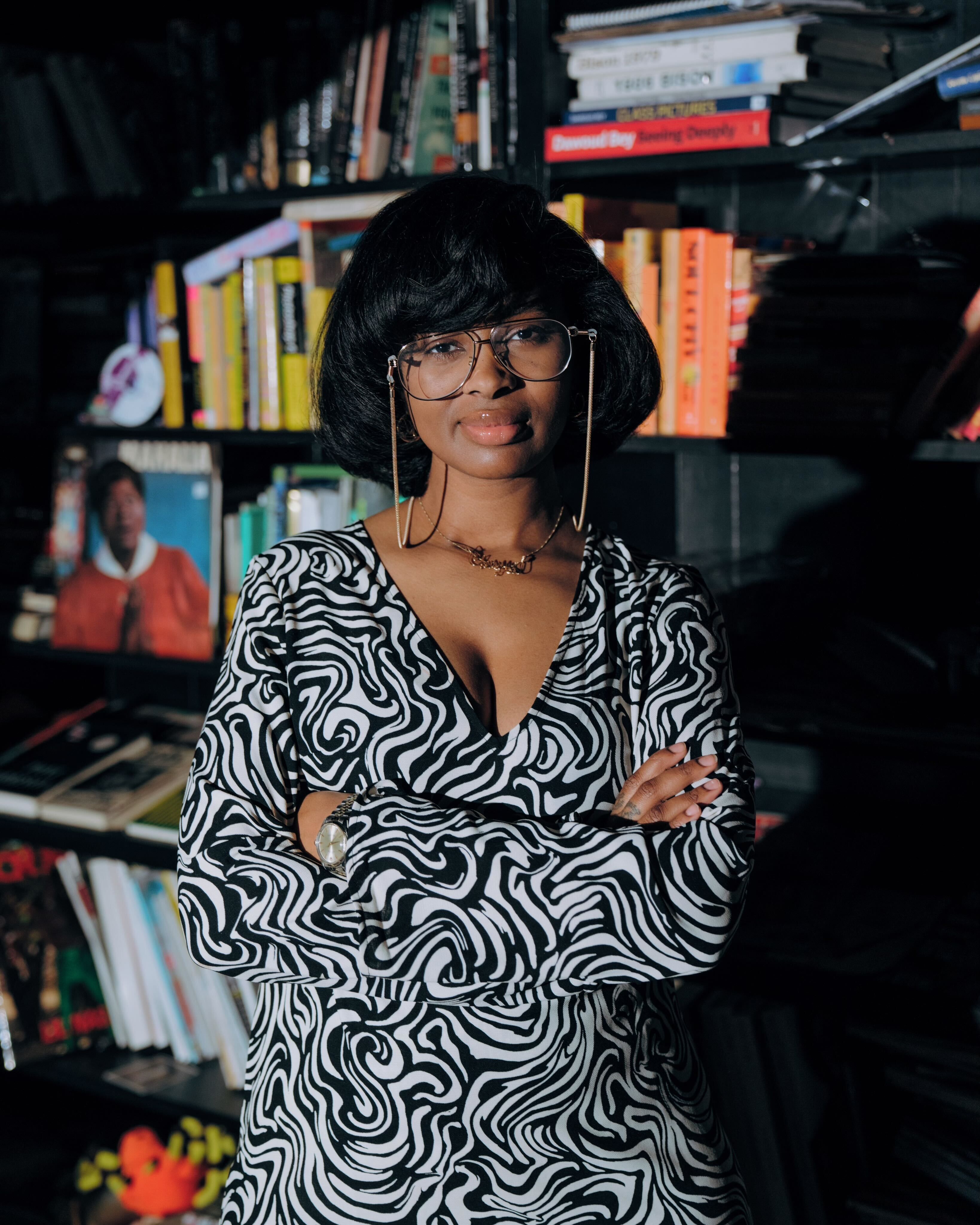 Cheryse Terry stands in front of a bookshelf. 