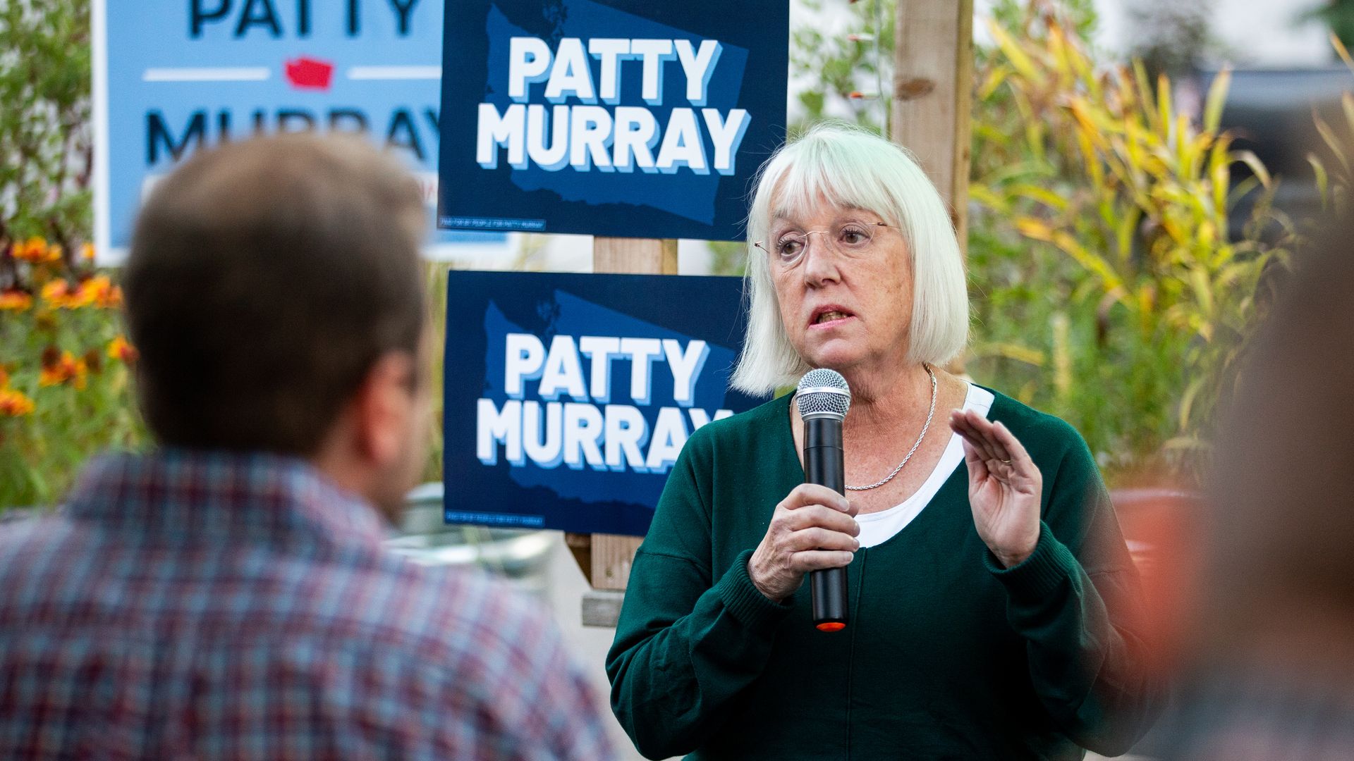 Patty  Murray speaks to a crowd with campaign signs behind her. 