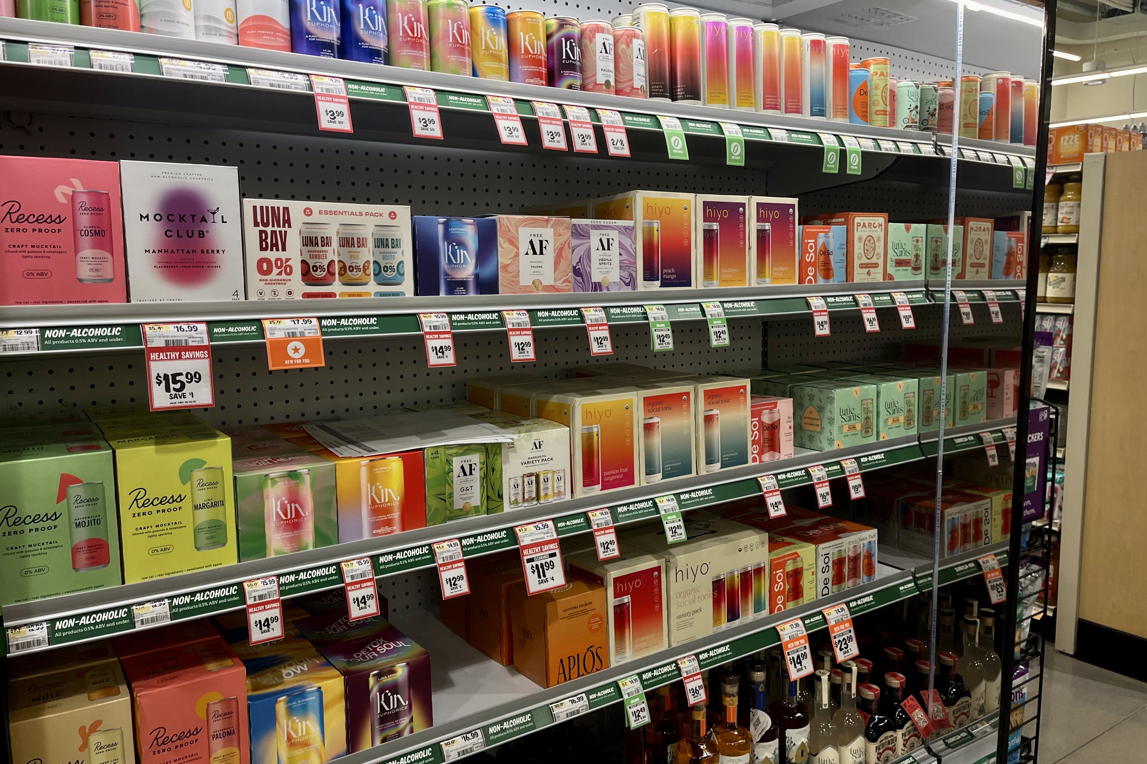 Grocery store shelf displaying a variety of colorful non-alcoholic beverages.