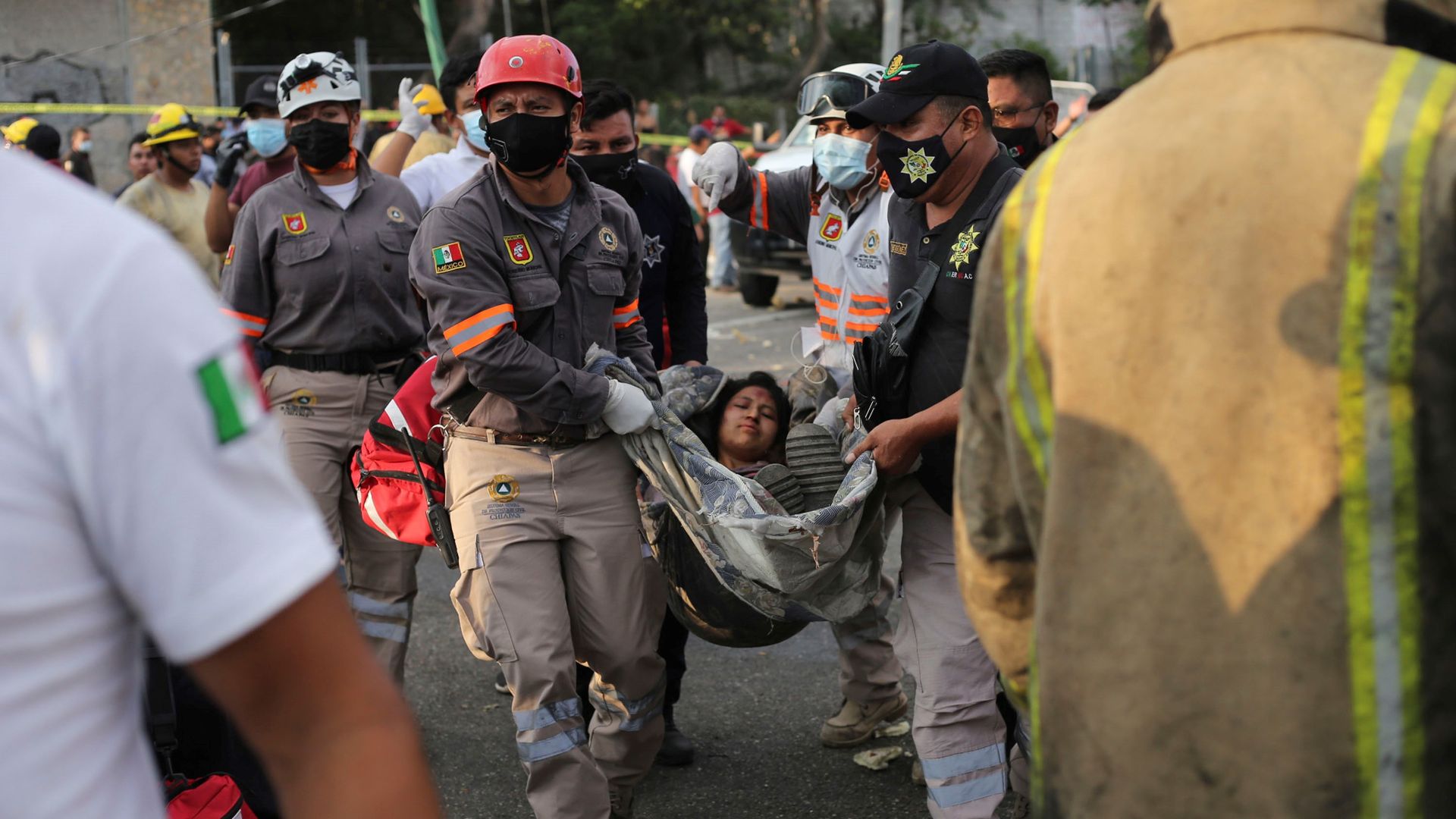 Rescue workers carry an injured woman from the site of an accident that killed more than 40 migrants.