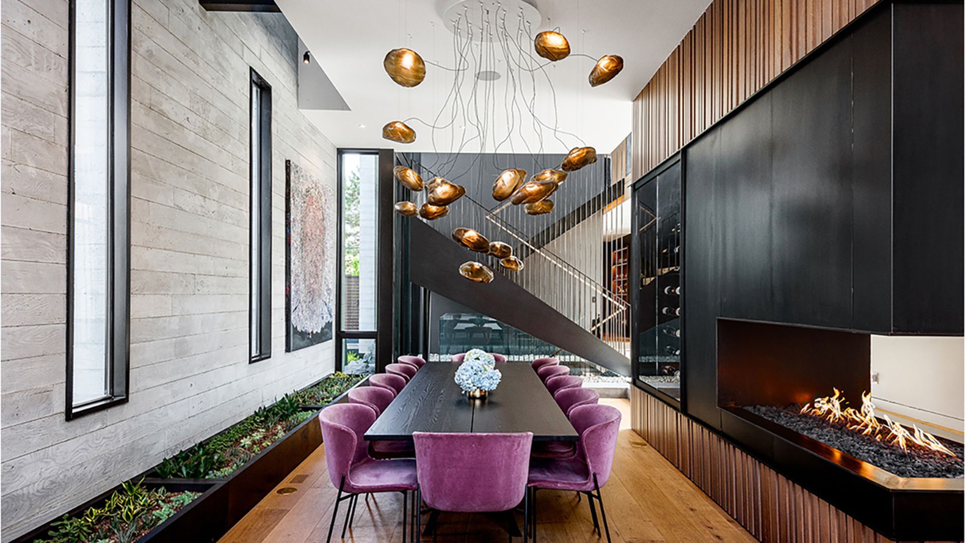 A dining table with purple chairs inside a spacious home.