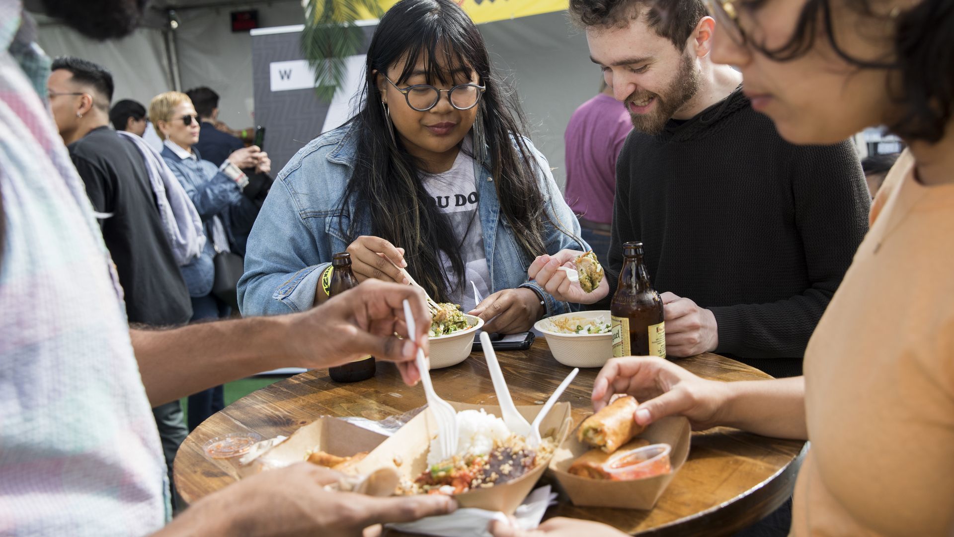 Photo of people eating food at an outdoor table