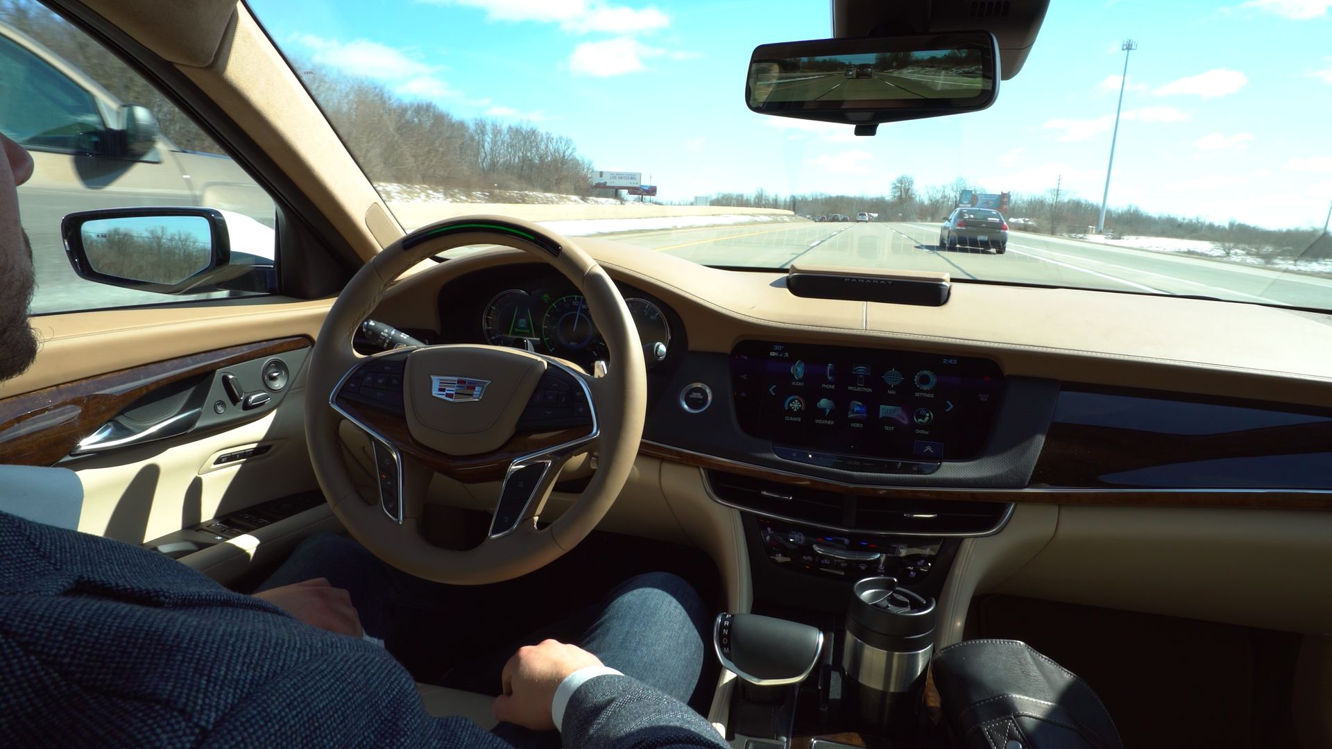Image of relaxed driver not holding the wheel in Cadillac equipped with hands-free Super Cruise technology.