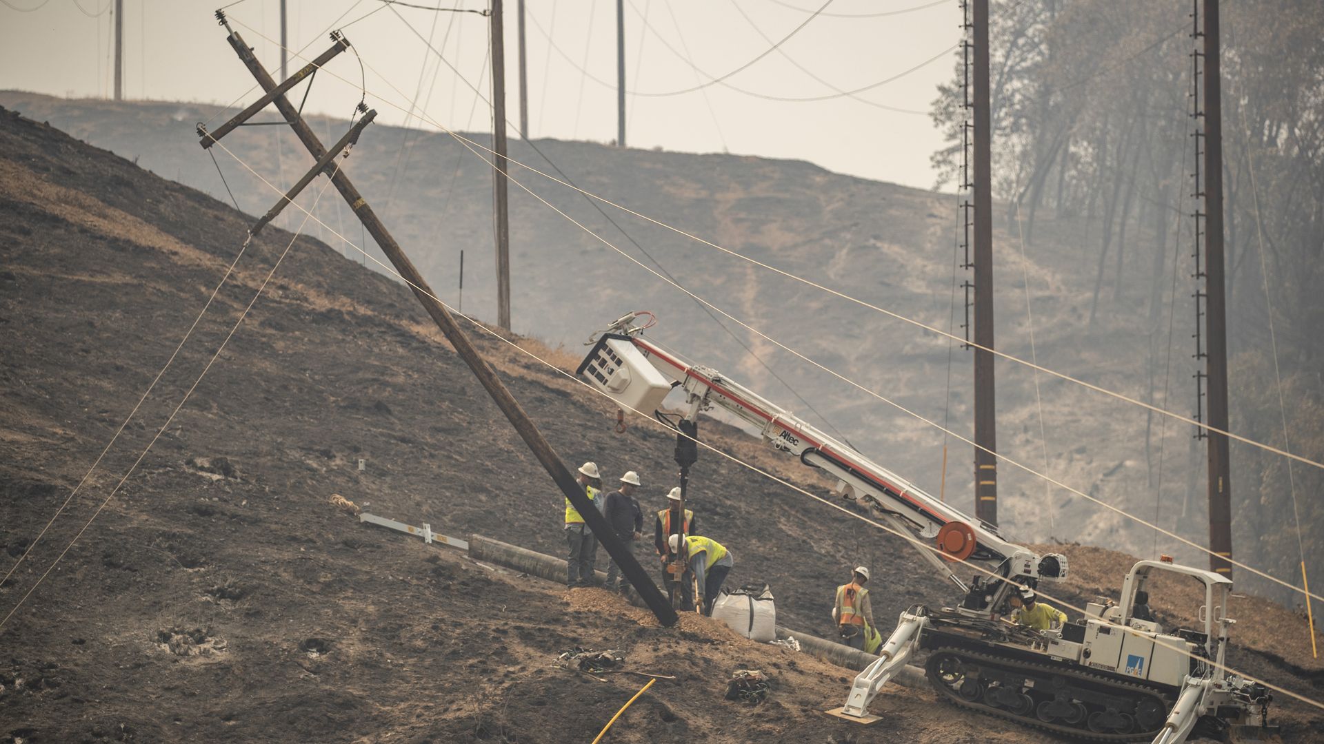 Utility workers with Pacific Gas & Electric Company repair a damaged power line near Lakehead, California, on July 2.