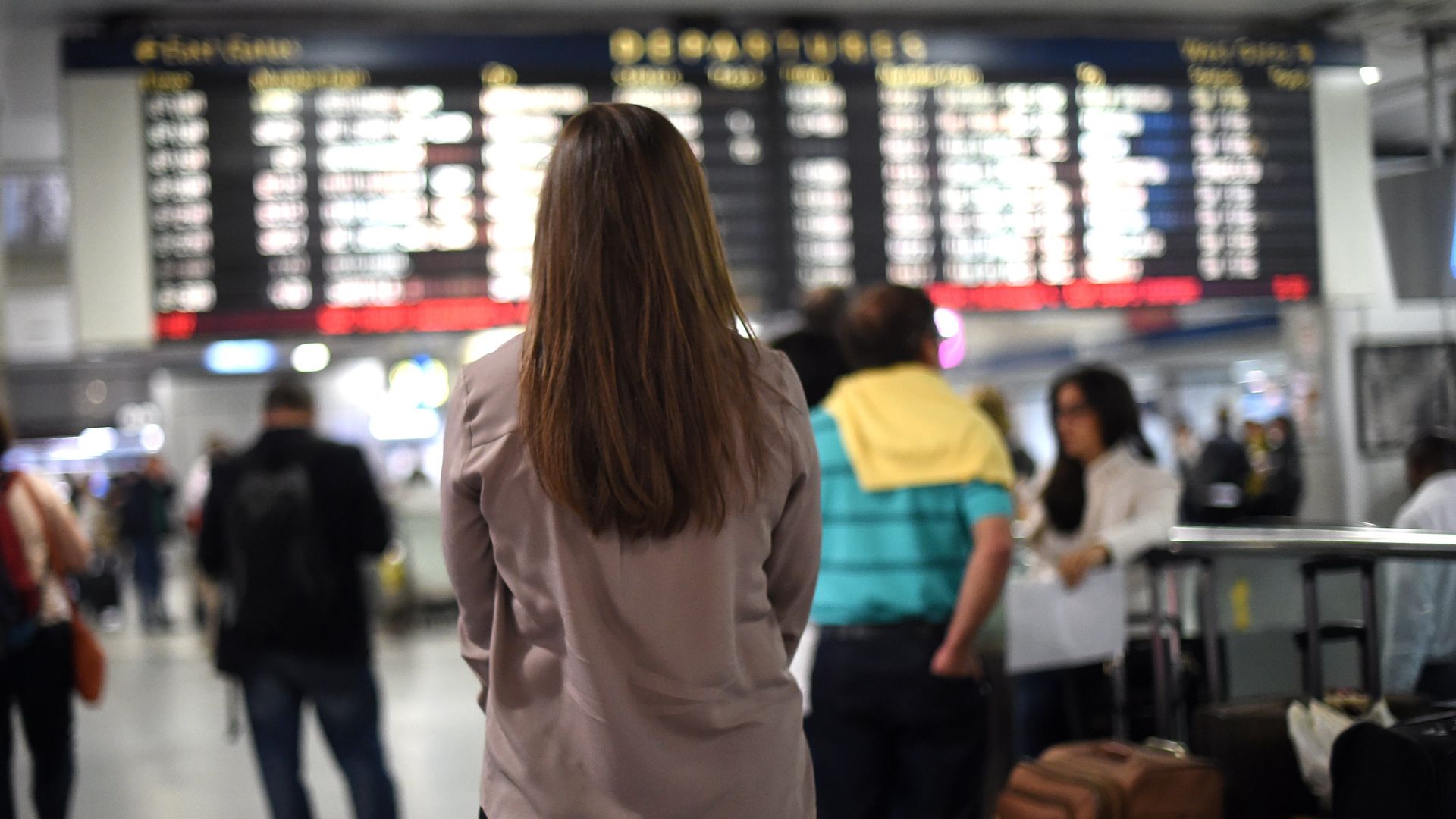 A woman in front of the departures board at Penn Station