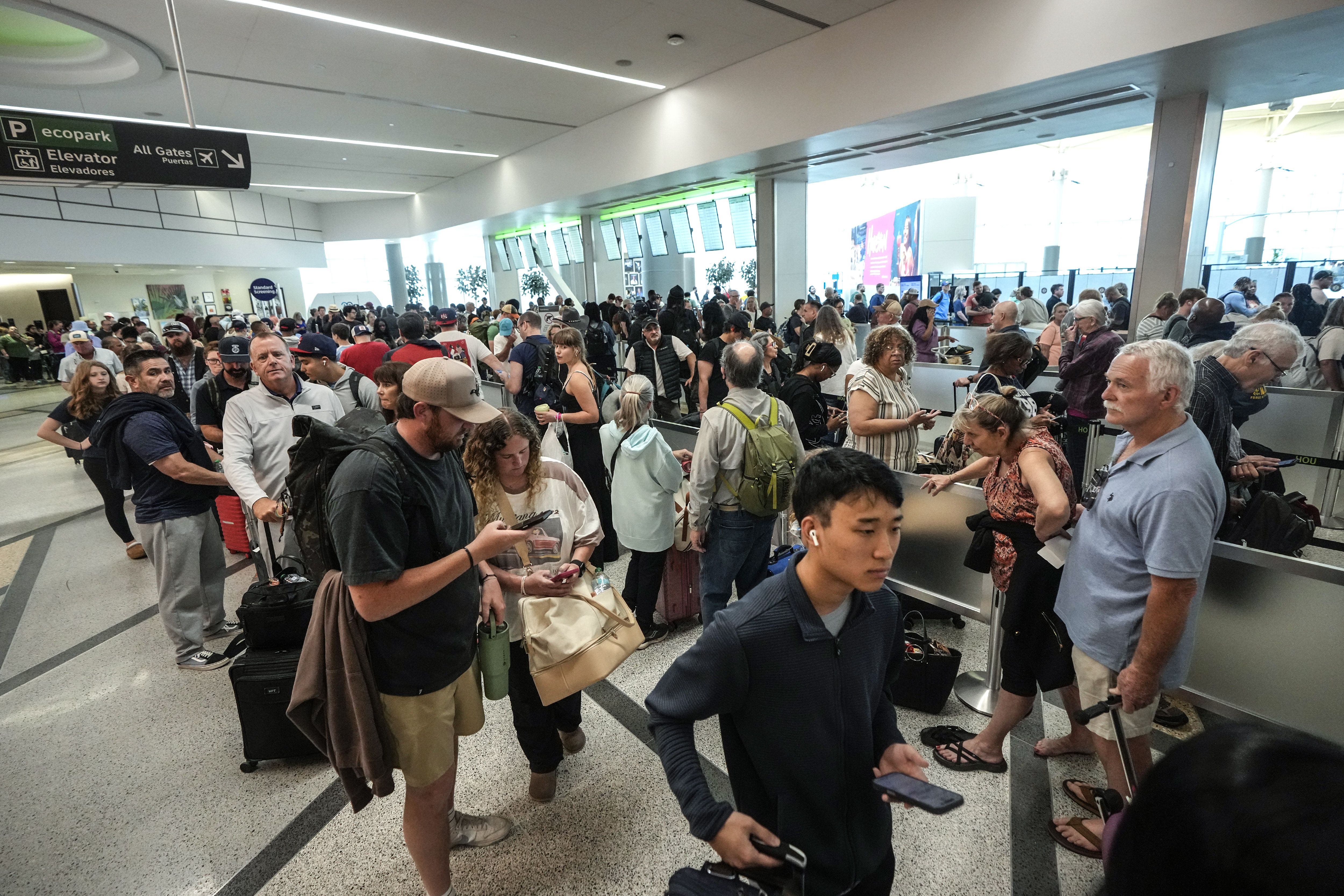 Airline passengers wait in long lines to get through the TSA security screening at William P. Hobby Airport in Houston, Sunday, March 8, 2026.
