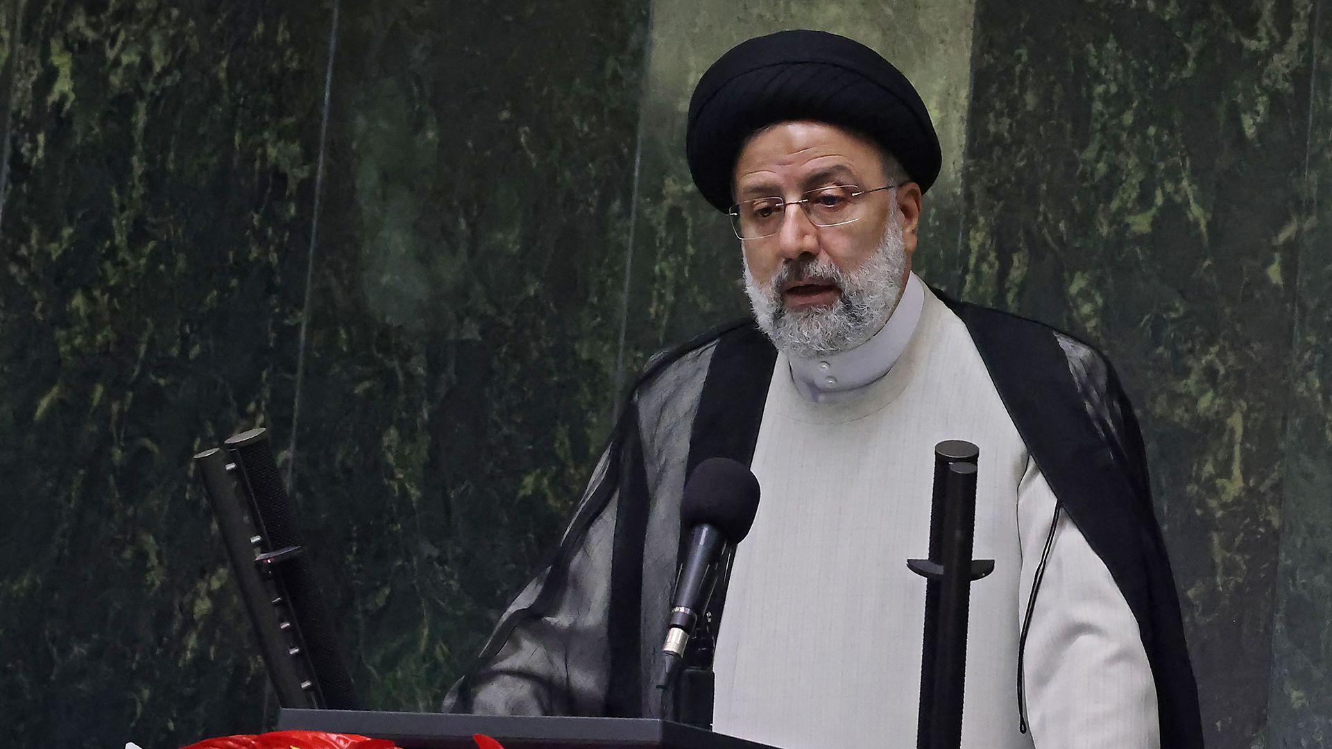Photo of Ebrahim Raisi speaking from a podium during a swearing-in ceremony