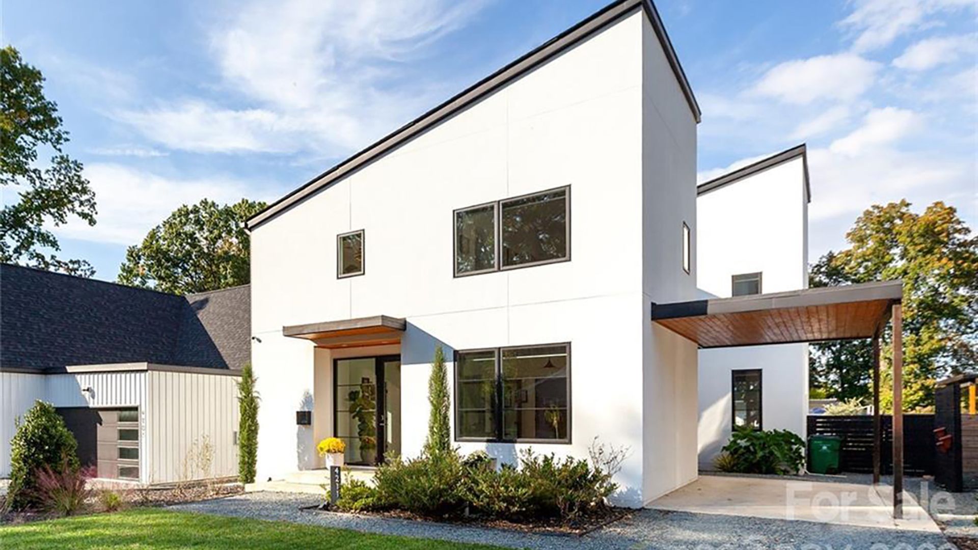 white two-story home that has an angular, modern roof