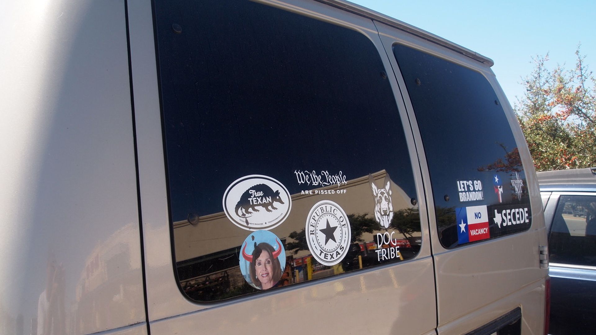 Bumper stickers on the back of a van.