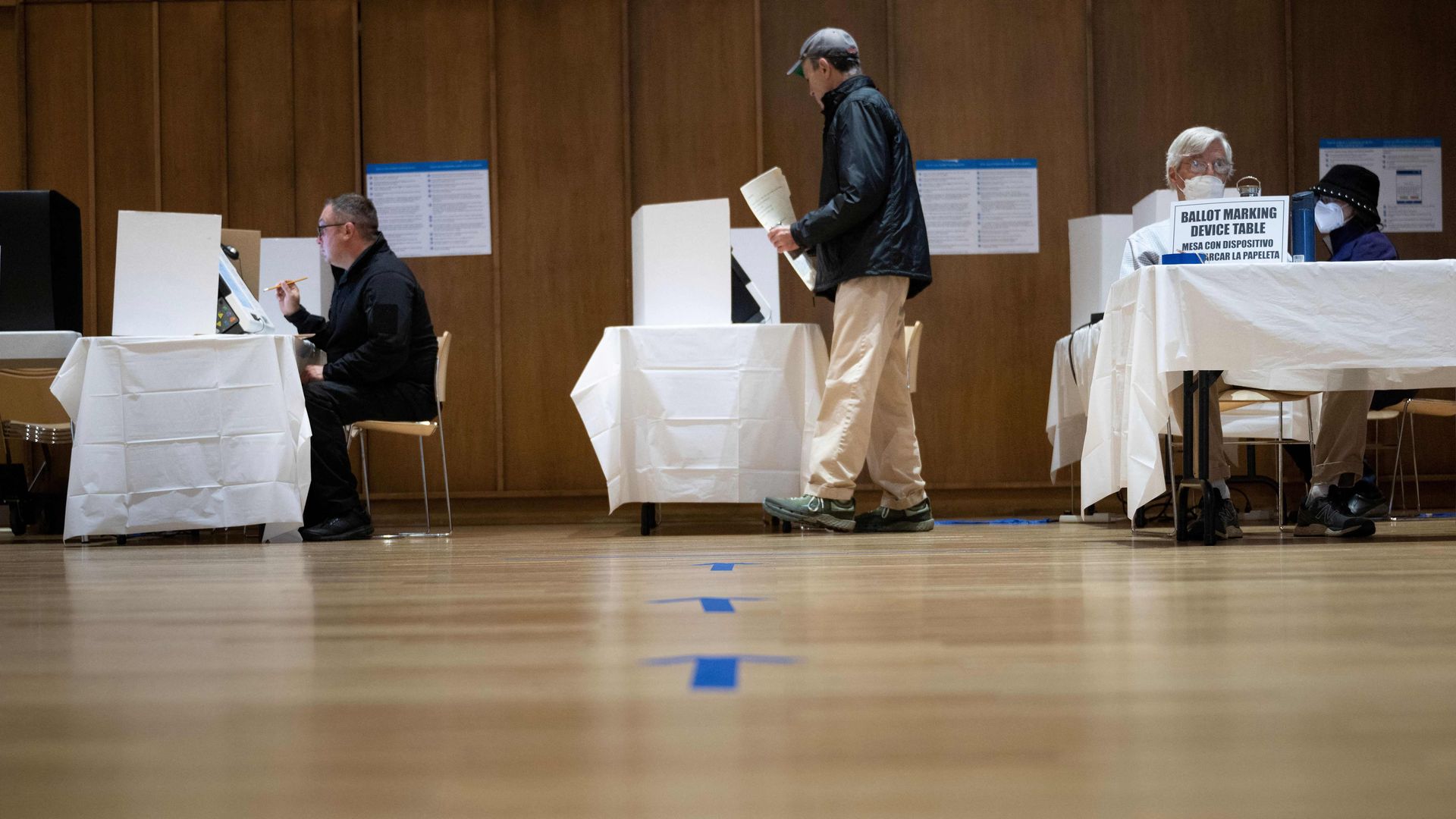 Voters and polling place workers are seen during early voting for the US midterm elections on October 28, 2022 in Silver Spring, Maryland.