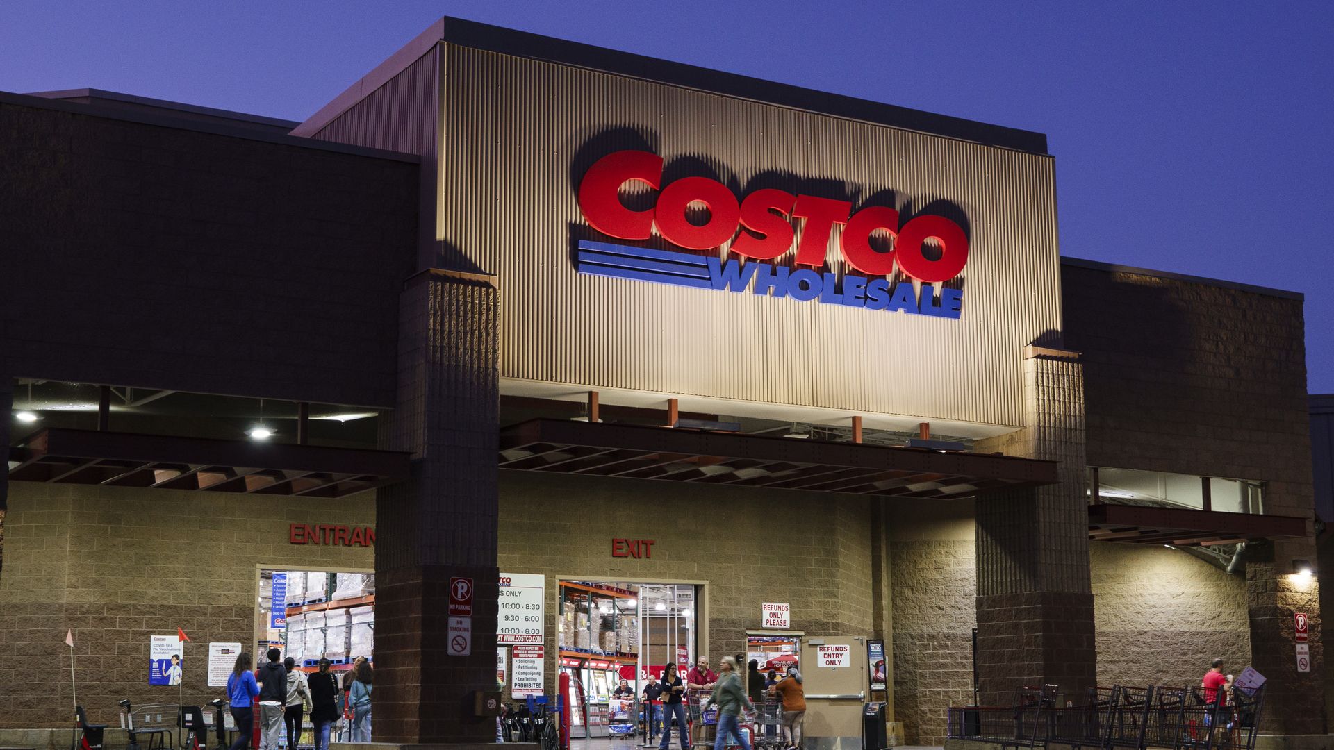 A big box store at night with the logo for Costco