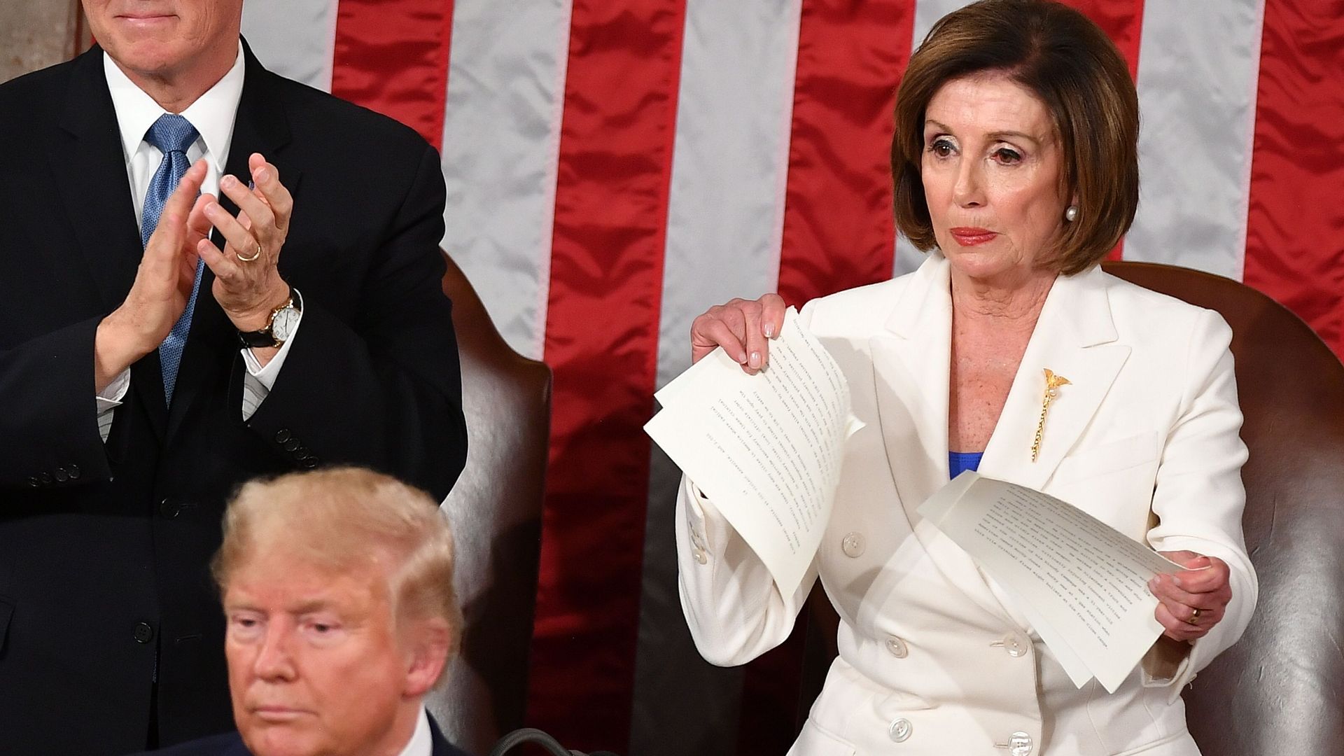 Vice President Mike Pence claps behind President Trump as Speaker Nancy Pelosi rips a printed copy of the State of the Union speech in the House chamber.