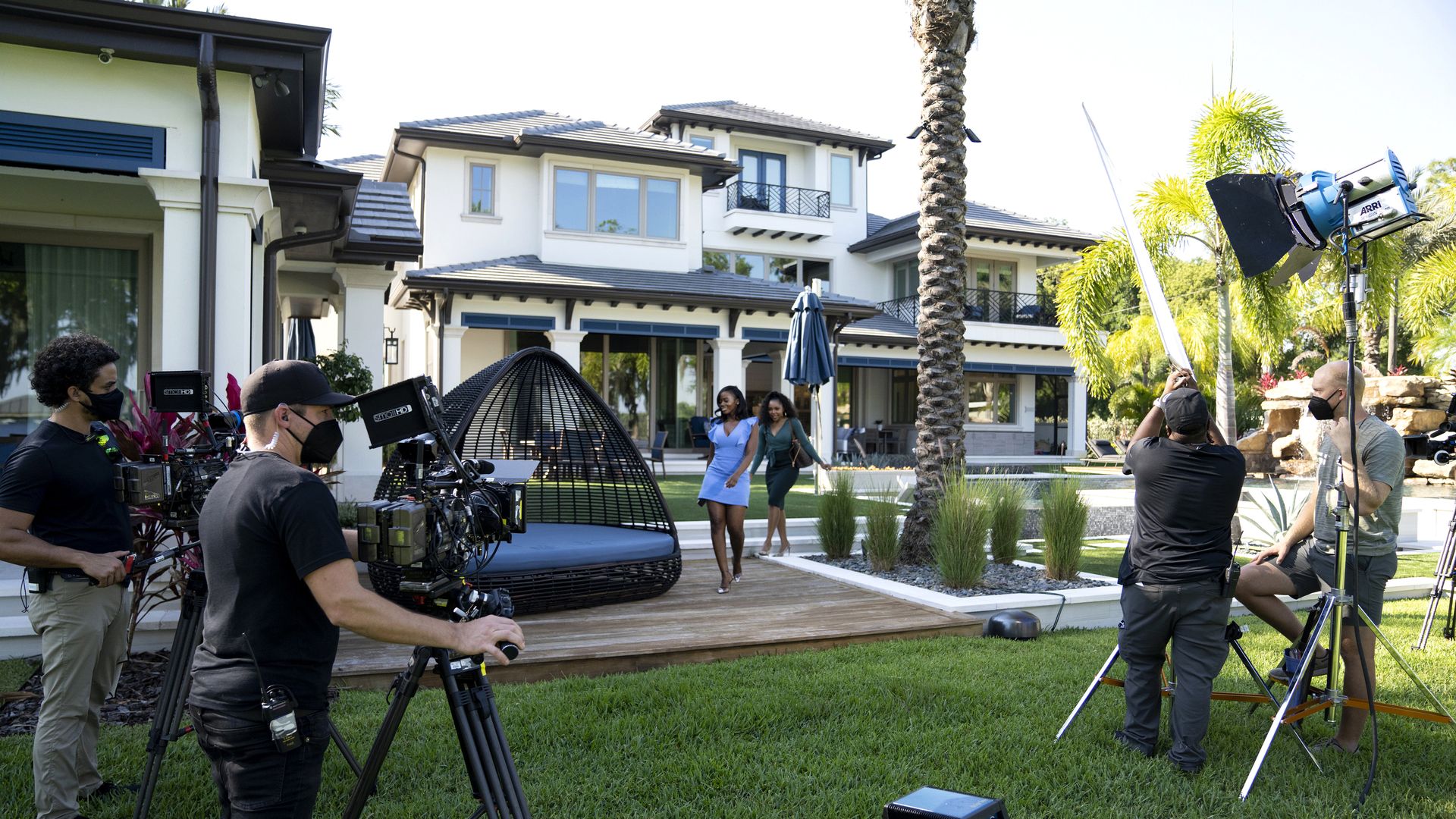 fancy house on camera with two real estate agents