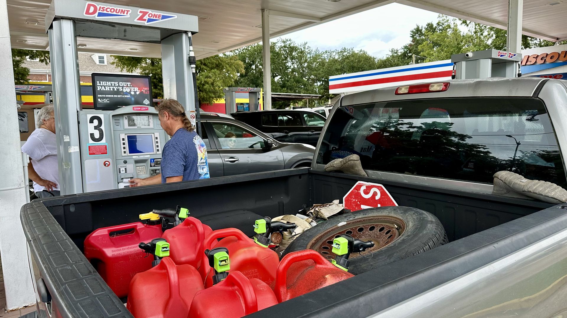 Image shows a truck bed with red gas tanks in it.
