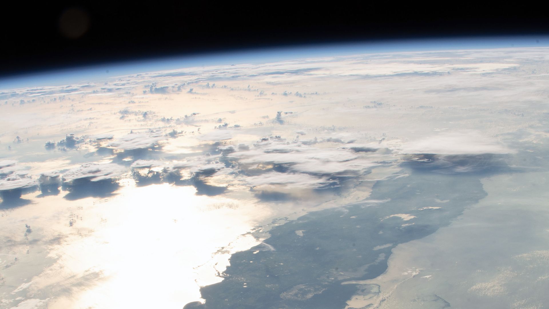 A photo of the straits of Florida with sunlight glinting off the water from space