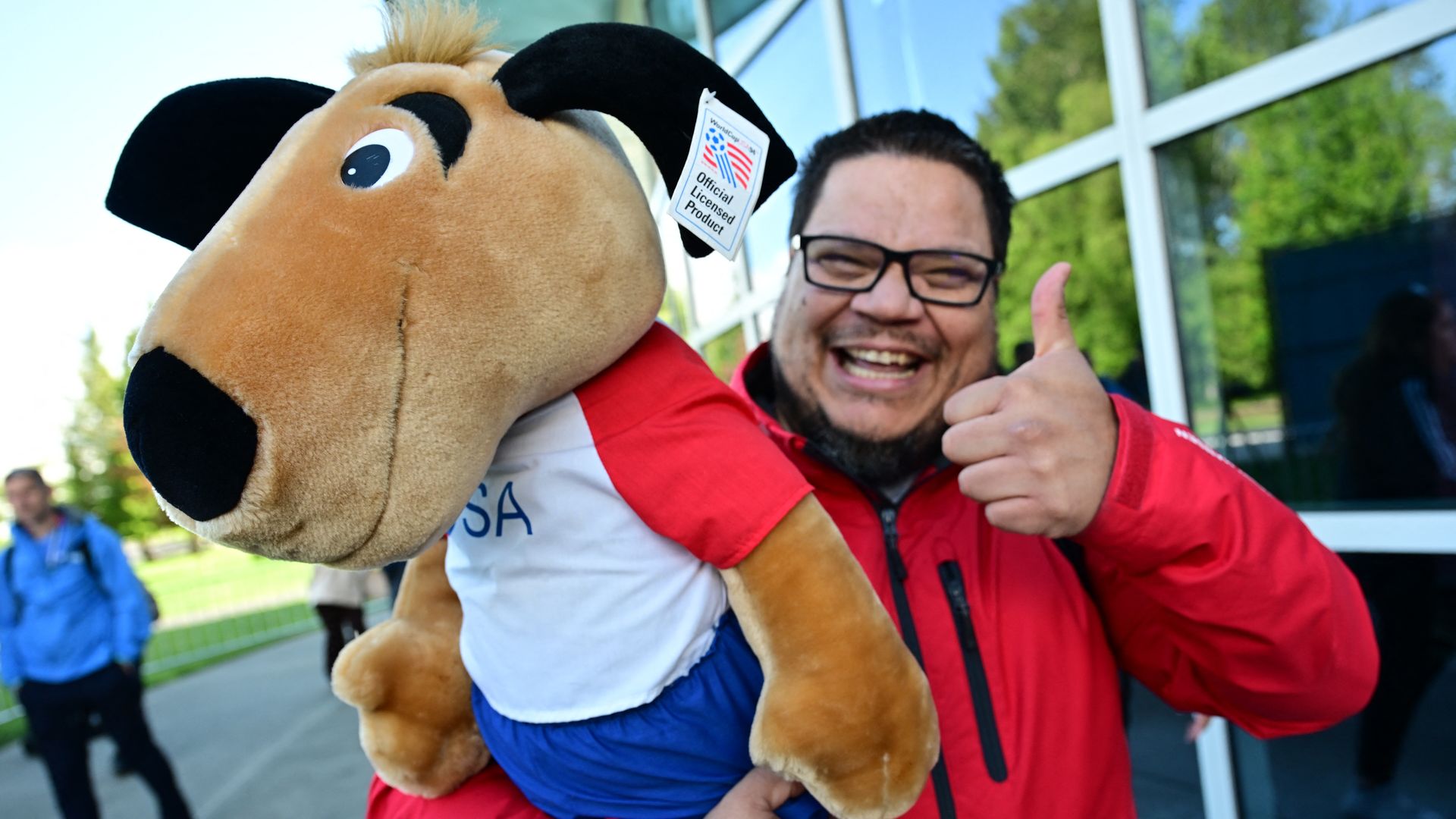 A man holding a World Cup mascot gives a thumbs up in Seattle.