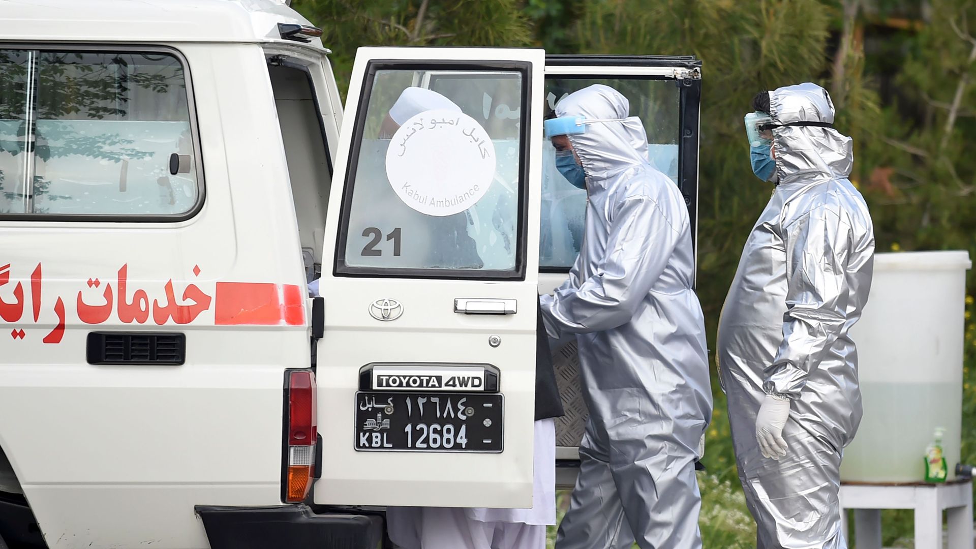 , medical staff members wearing personal protective equipment (PPE) prepare to assist a suspected COVID-19 coronavirus patient in Kabul. 