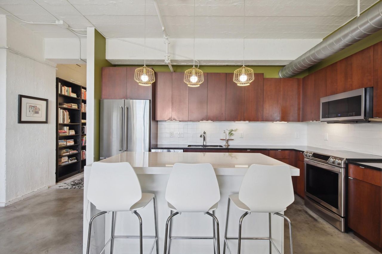 modern kitchen that faces living area and has modern appliances and island