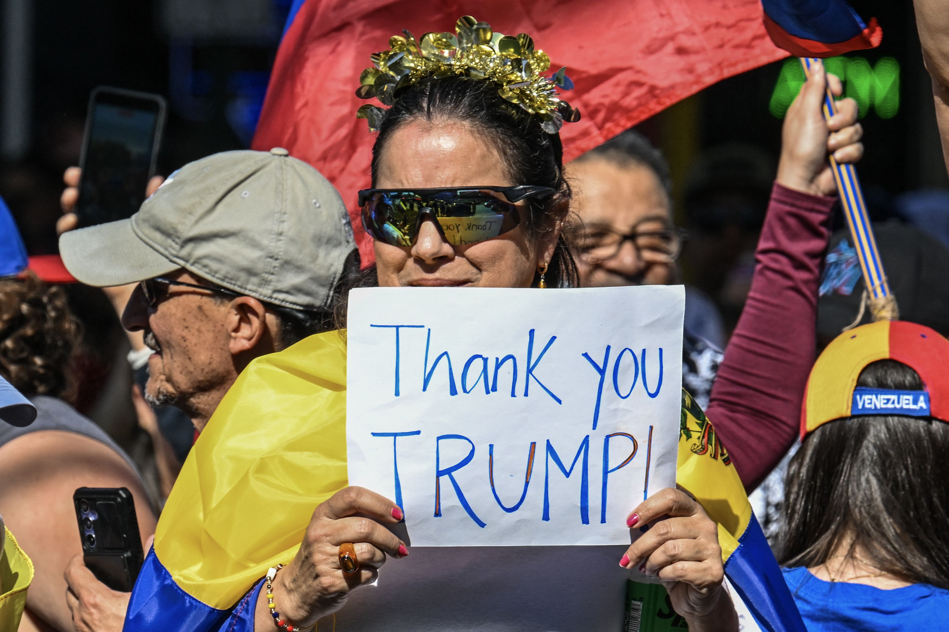 A woman holds up a sign that reads "Thank you TRUMP!"