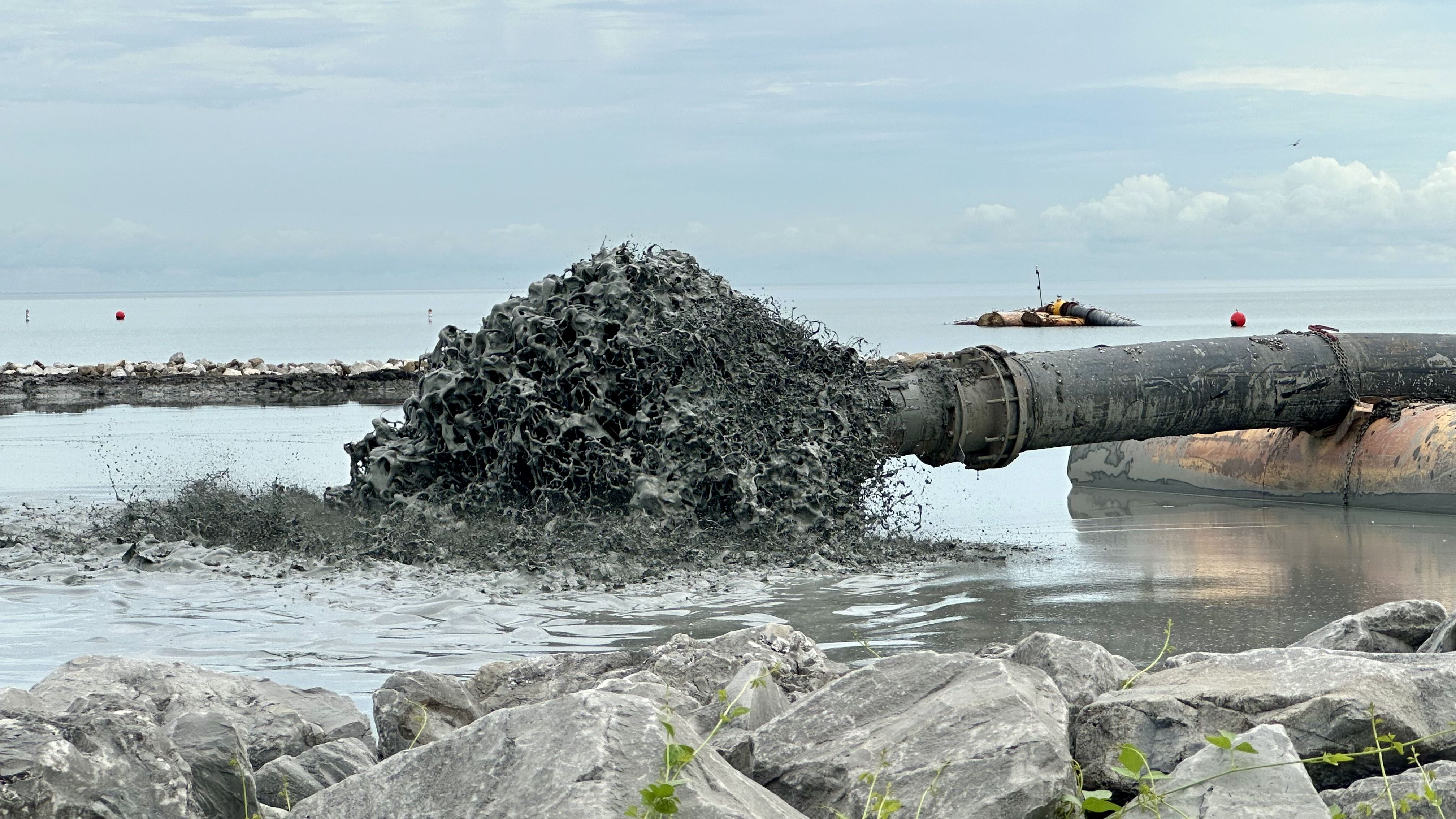 Image shows sediment coming out of a pipe.