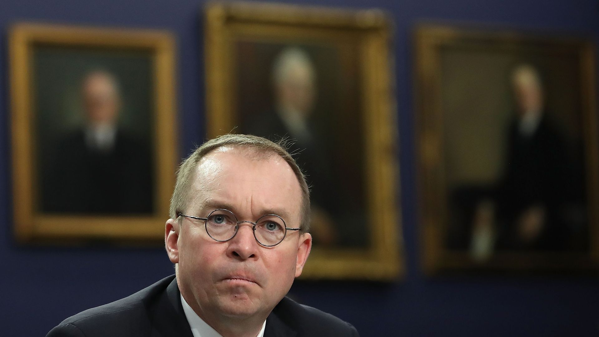 Mick Mulvaney looking straight at the camera with an unhappy look on his face