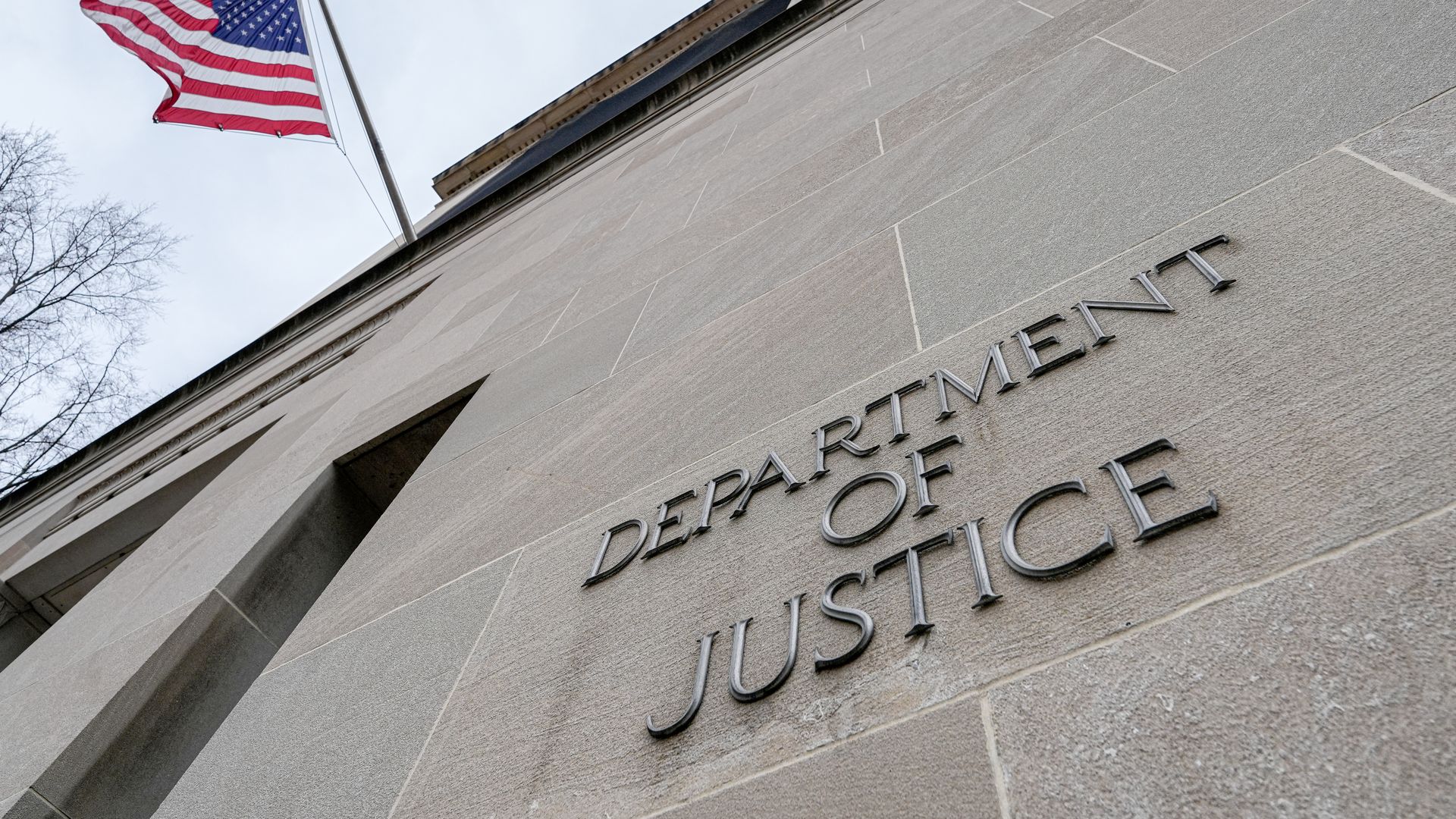  The US Flag flies above a sign marking the US Department of Justice (DOJ) headquarters building on January 20, 2024, in Washington, DC. 