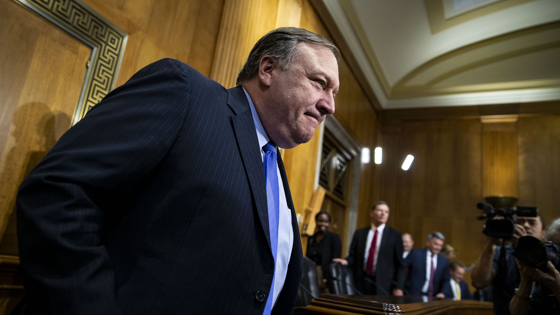 Mike Pompeo stands for a hearing on Capitol Hill, grimacing.