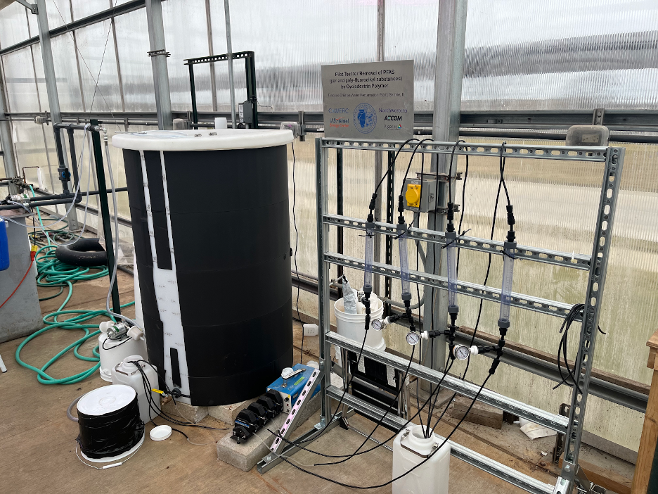 Four tubes are hanging from wires as part of a larger experiment.