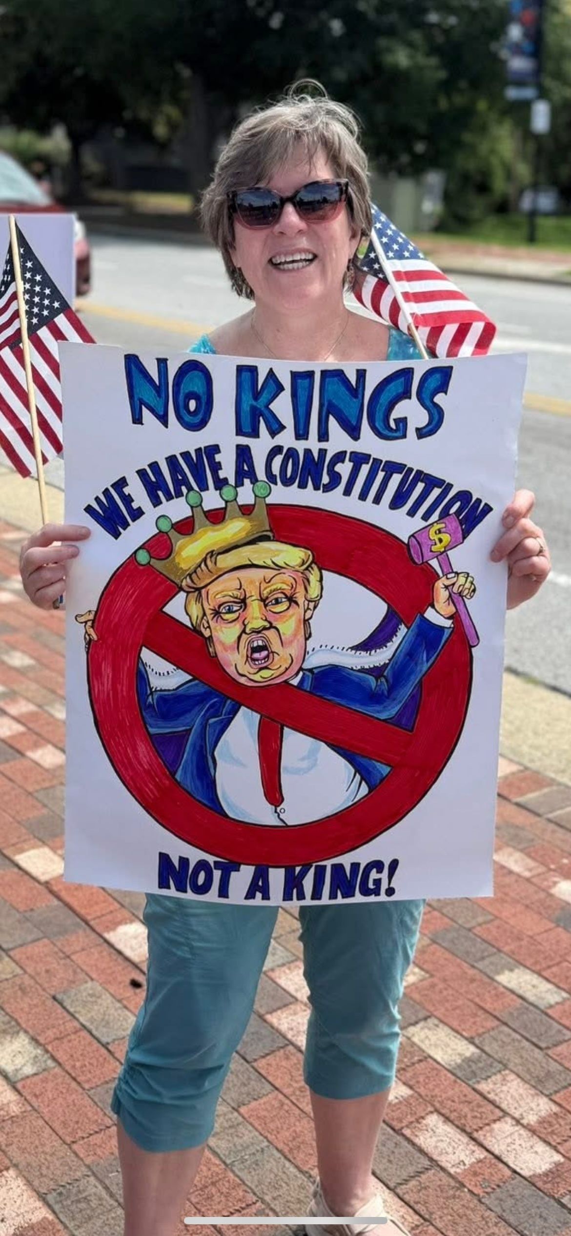 A woman holds a protest sign signing "No kings, we have a Constitution" during an anti-Trump protest in Jamestown, North Carolina.