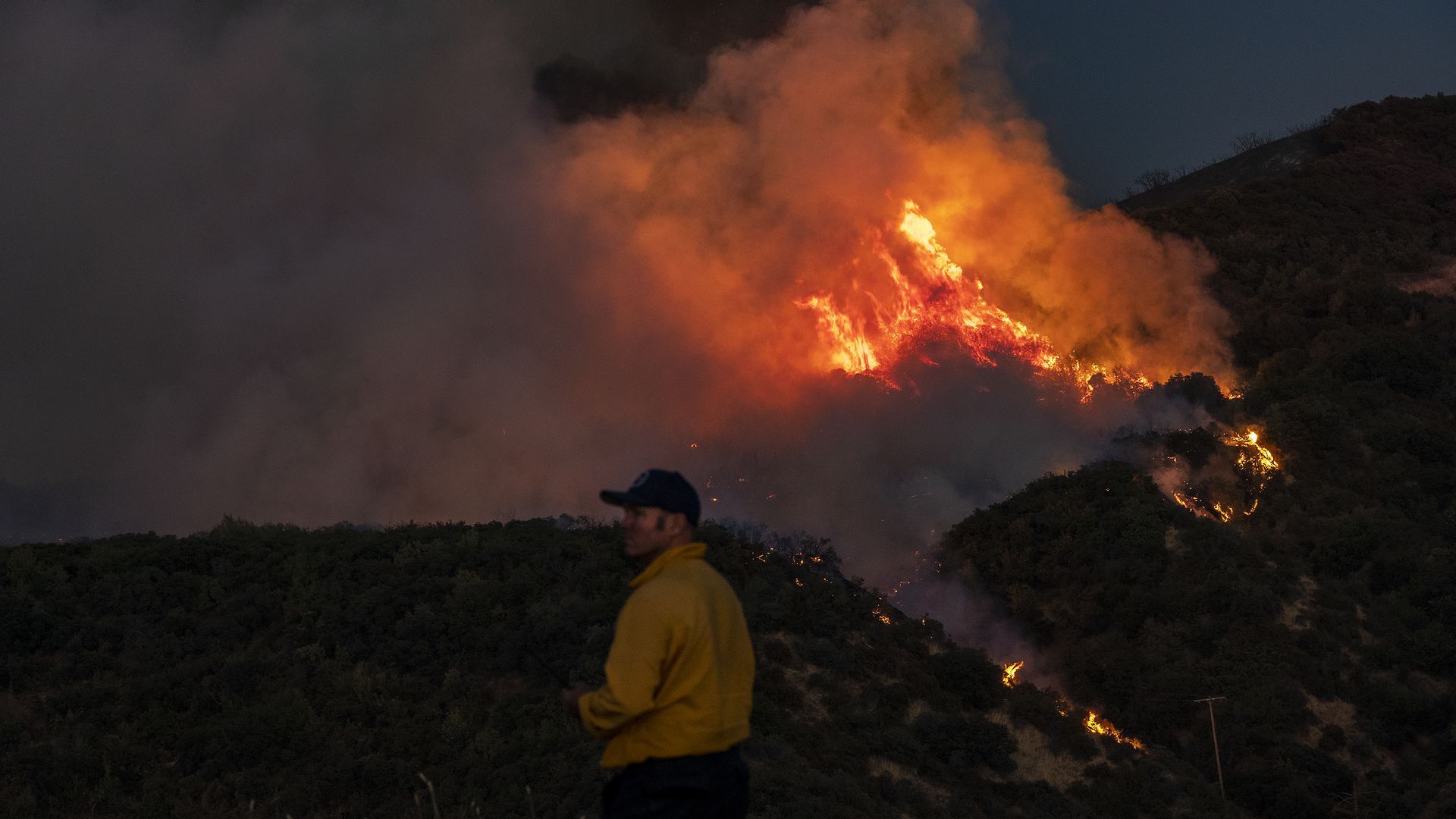 A firefighter from Carpinteria monitors a flare-up along a ridge as the Apple fire burns north of Banning in Cherry Valley, California, on Aug. 1. 