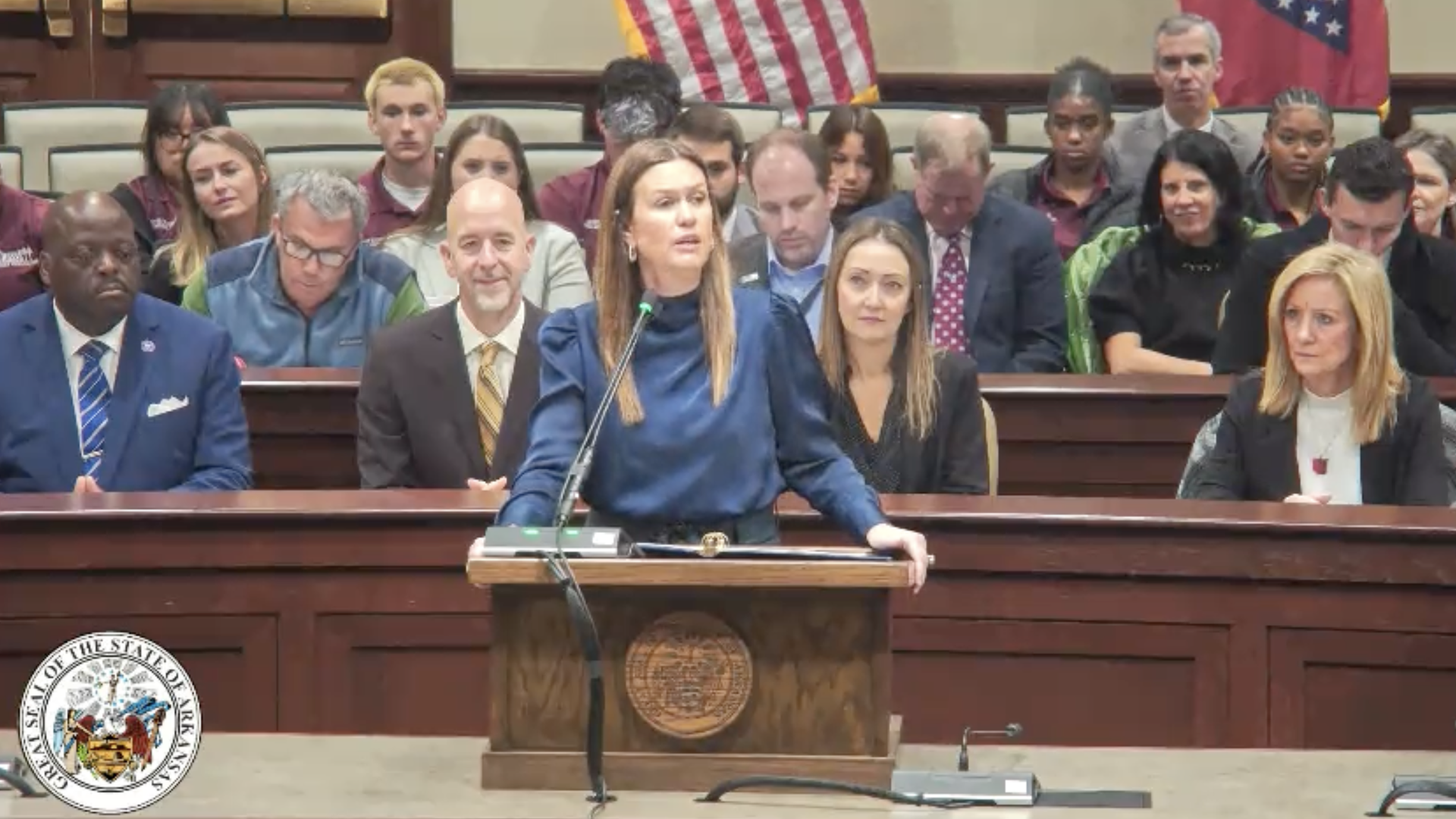 Arkansas Gov. Sarah Huckabee Sanders speaks at a podium.