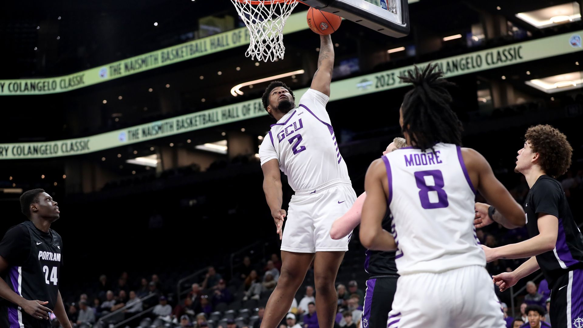 A basketball player dunks the ball during a game.
