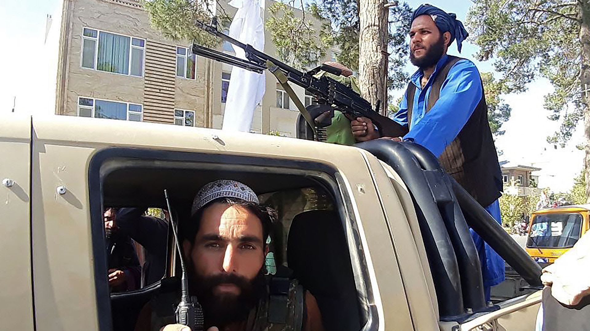 Taliban fighters in and on a car
