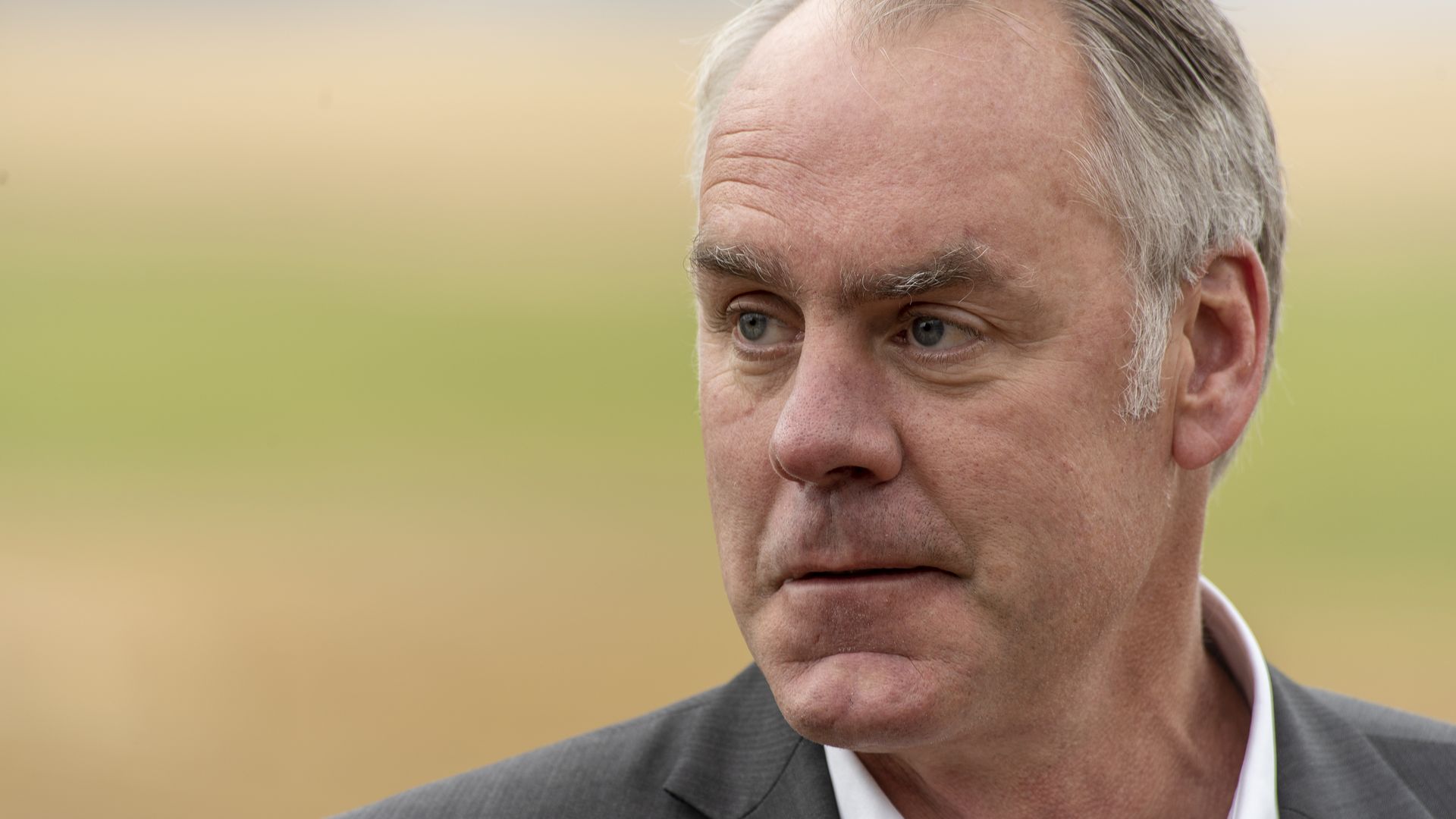 Zinke looks to his right.