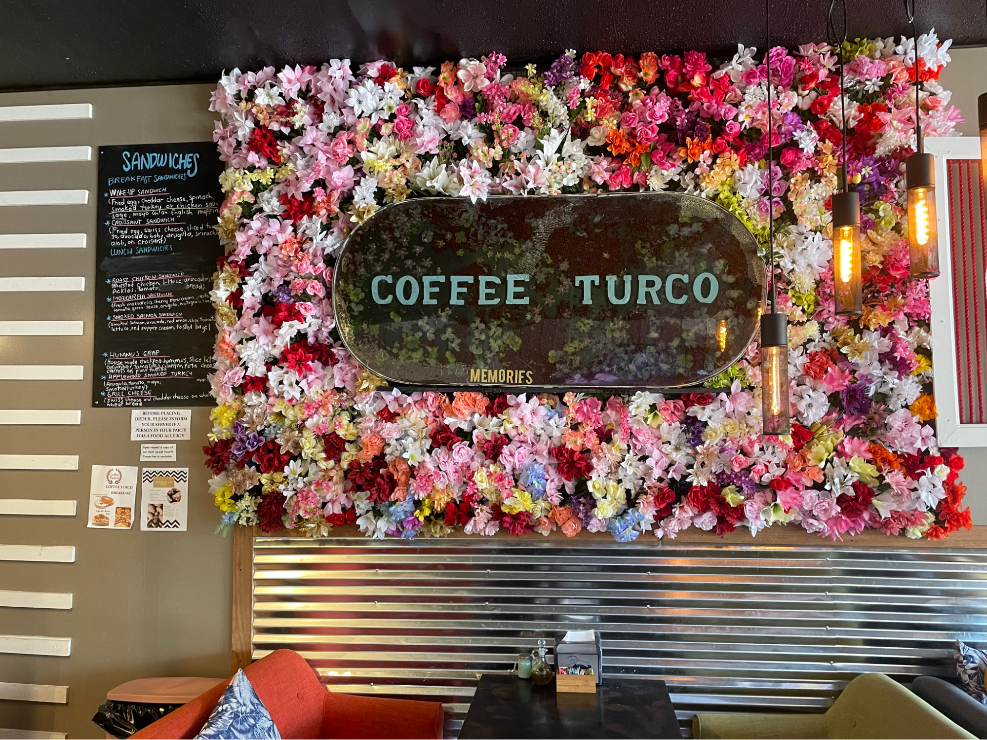 A flower wall with a sign that says Coffee Turco