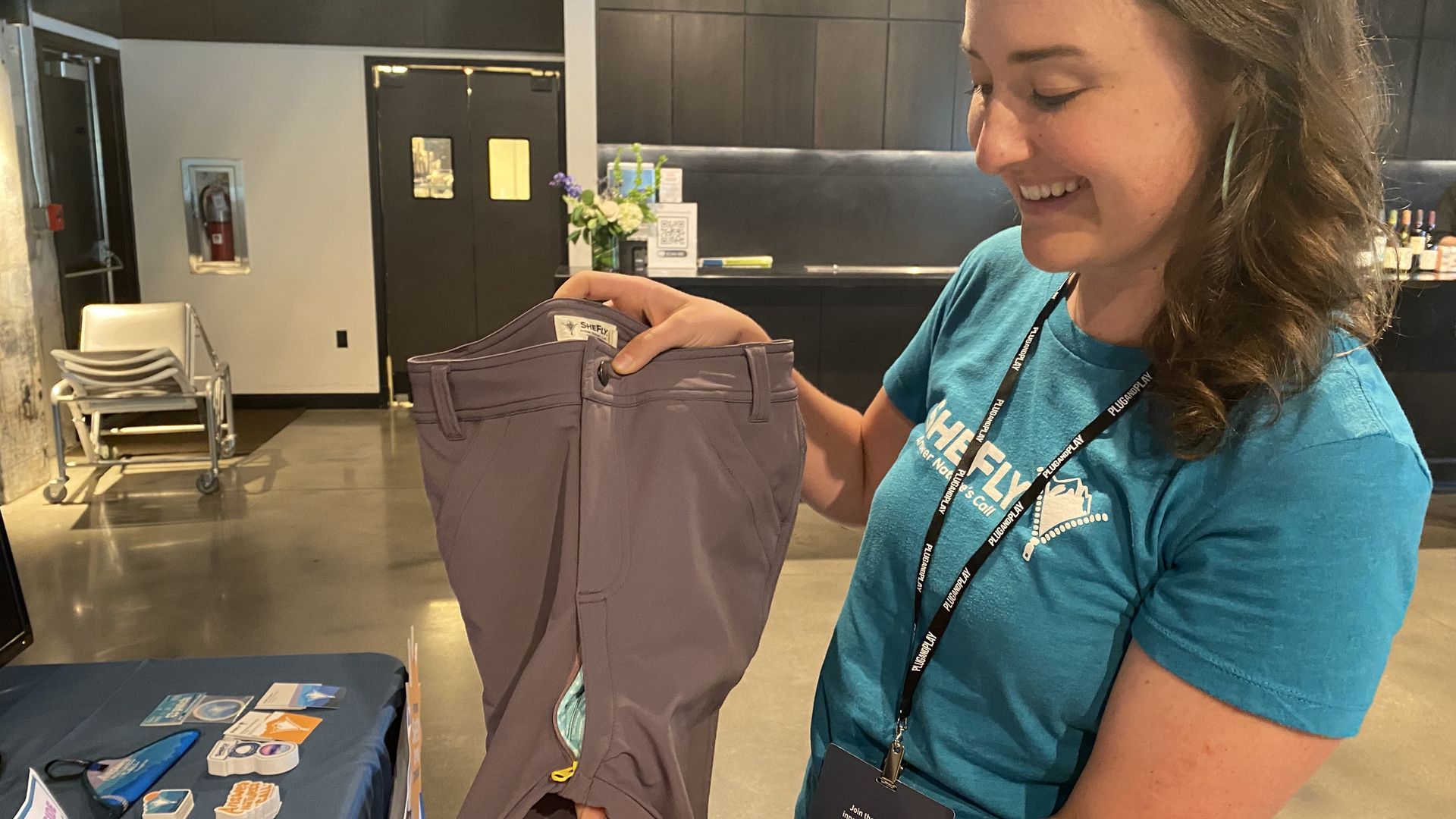 A woman shows off a pair of pants.