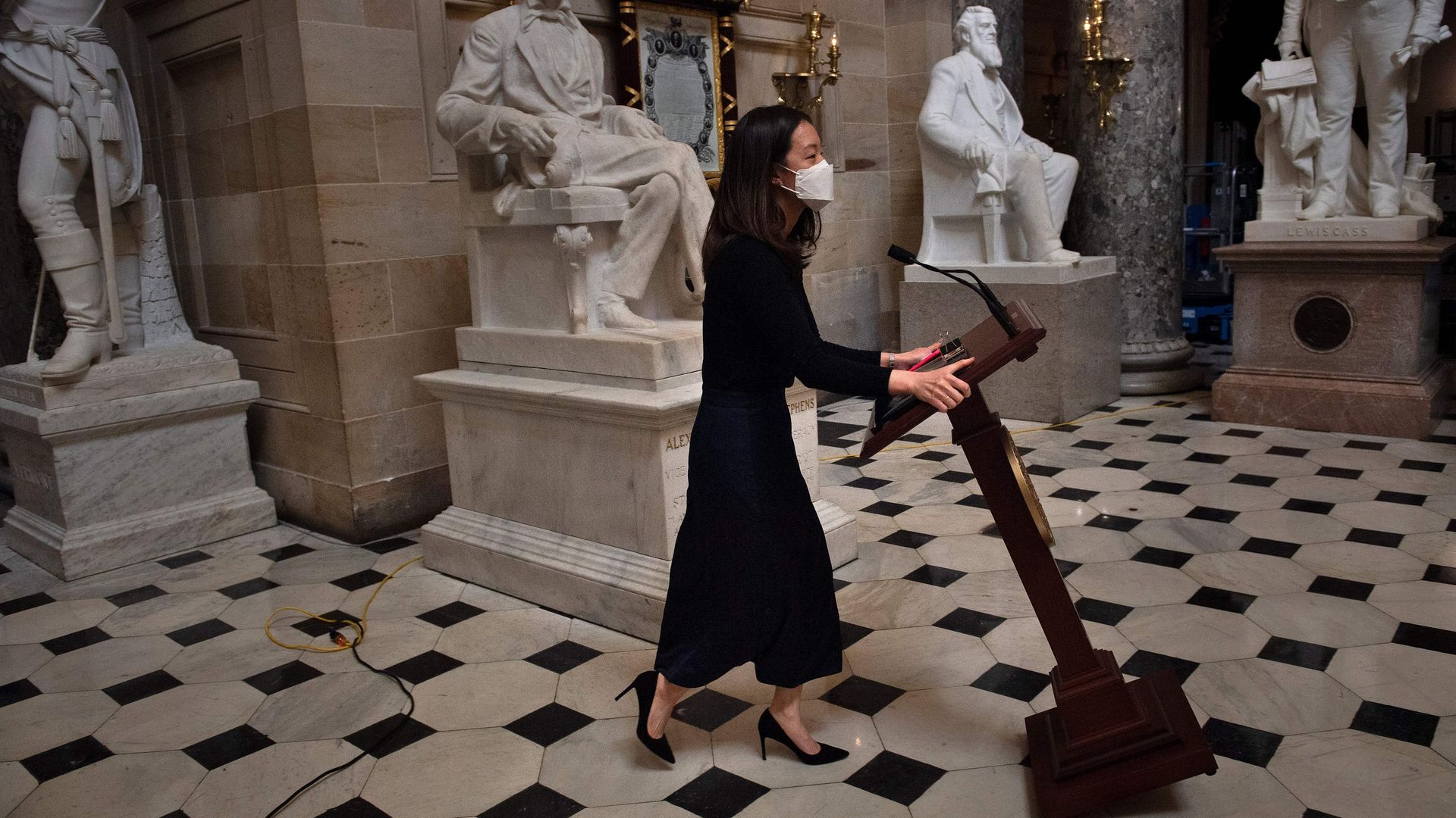 A House aide is seen wheeling the speaker's podium back through the Capitol after it was moved by invaders last week.