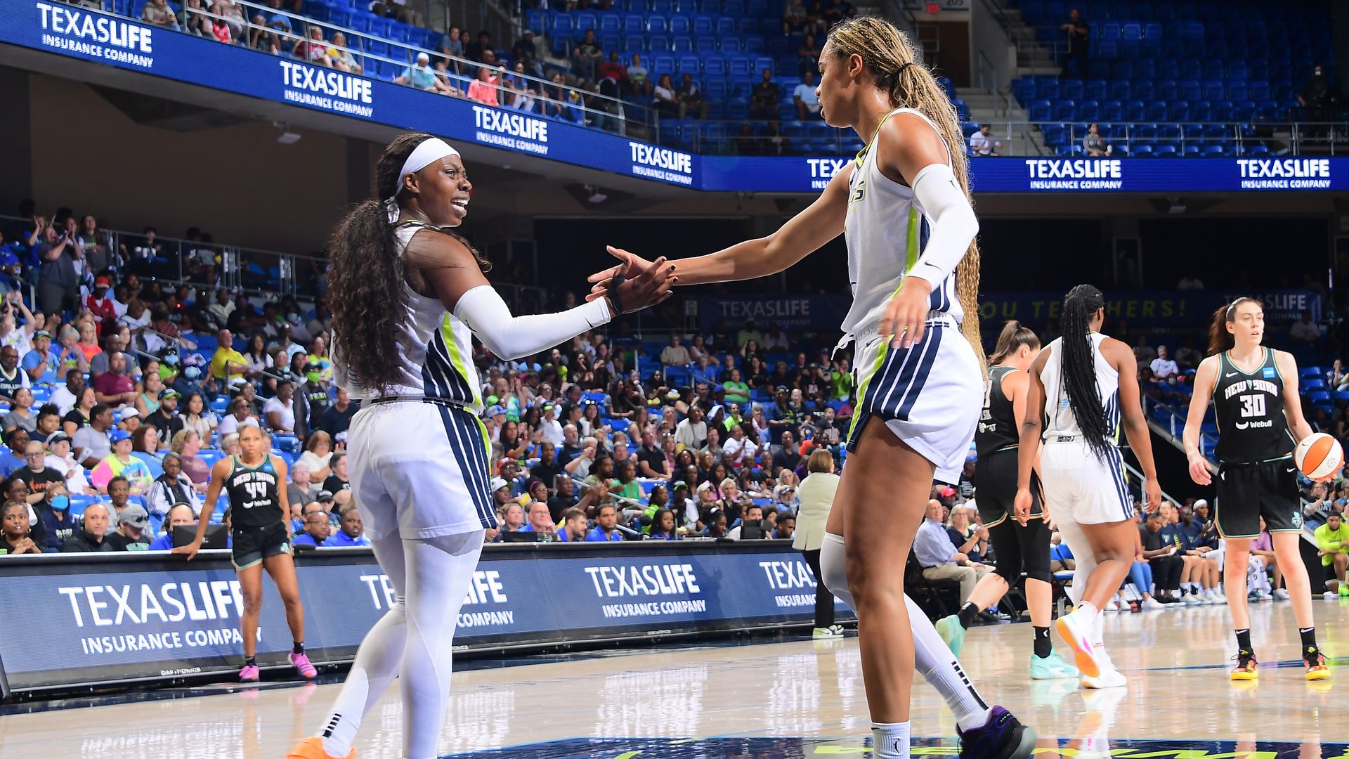 Dallas Wings player Arike Ogunbowale high fives Satou Sabally 