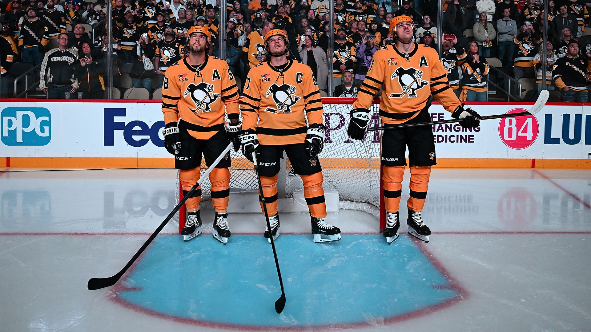 Kris Letang #58, Sidney Crosby #87 and Evgeni Malkin #71 of the Pittsburgh Penguins look on prior to the game against the New York Islanders at PPG PAINTS Arena on October 9, 2025 in Pittsburgh, Pennsylvania. (Photo by Joe Sargent/NHLI via Getty Images)