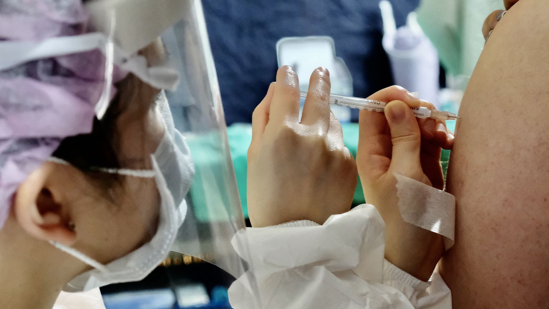 Picture of a person's arm as a health worker injects them with the Moderna vaccine