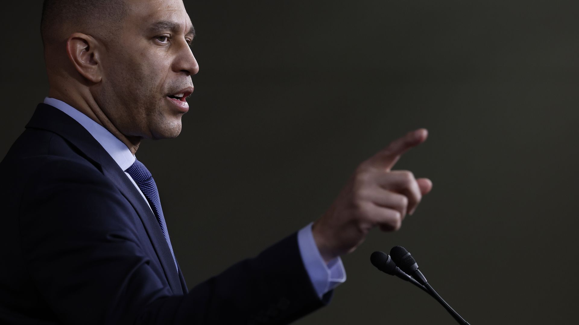 House Minority Leader Hakeem Jeffries, wearing a blue shirt, blue suit, and blue tie, standing at a microphone.