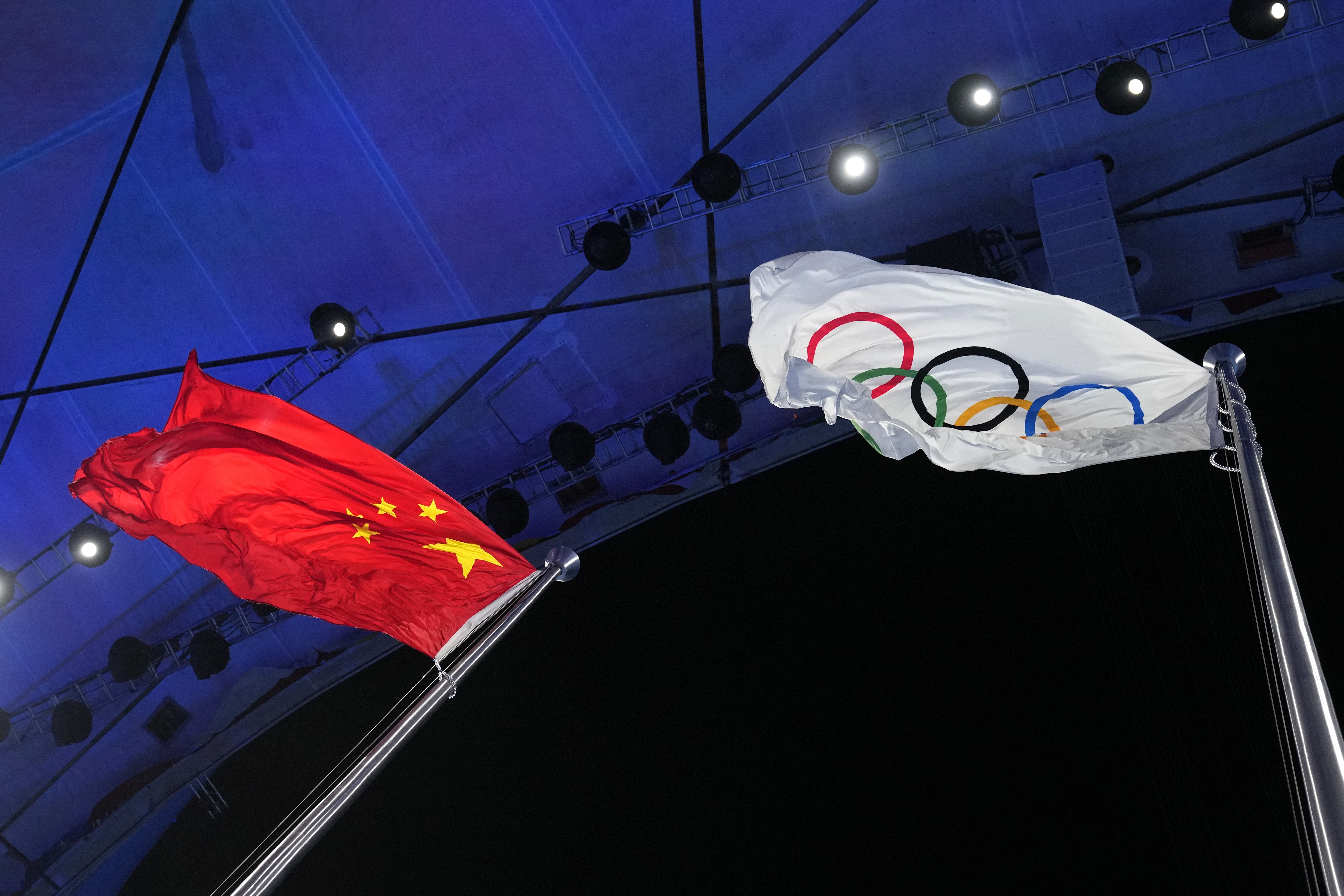 The Chinese and Olympic flags fly during the opening ceremony of the 2022 Winter Olympics, Friday, Feb. 4, 2022, in Beijing. 