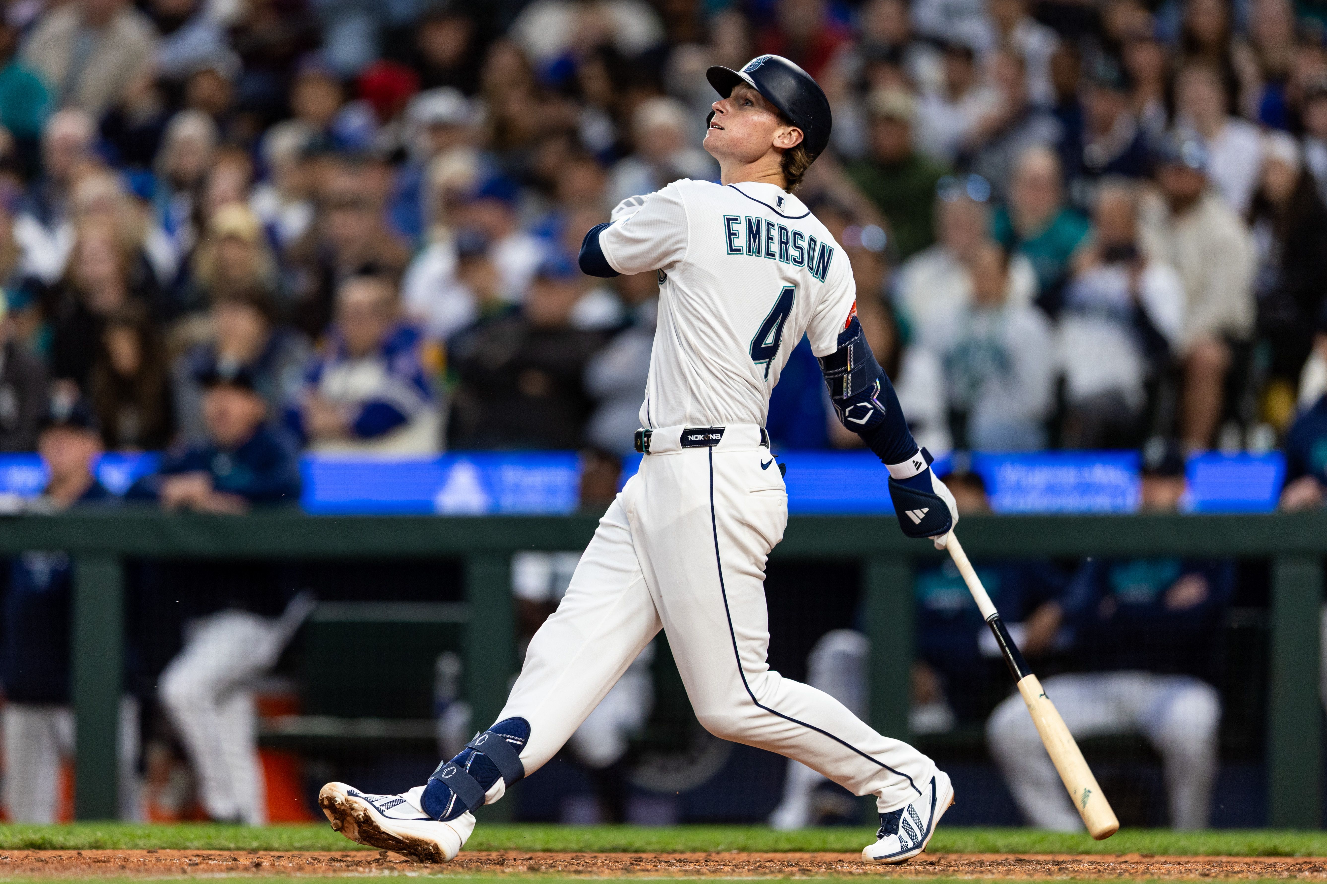A baseball player watches the ball after the swing.