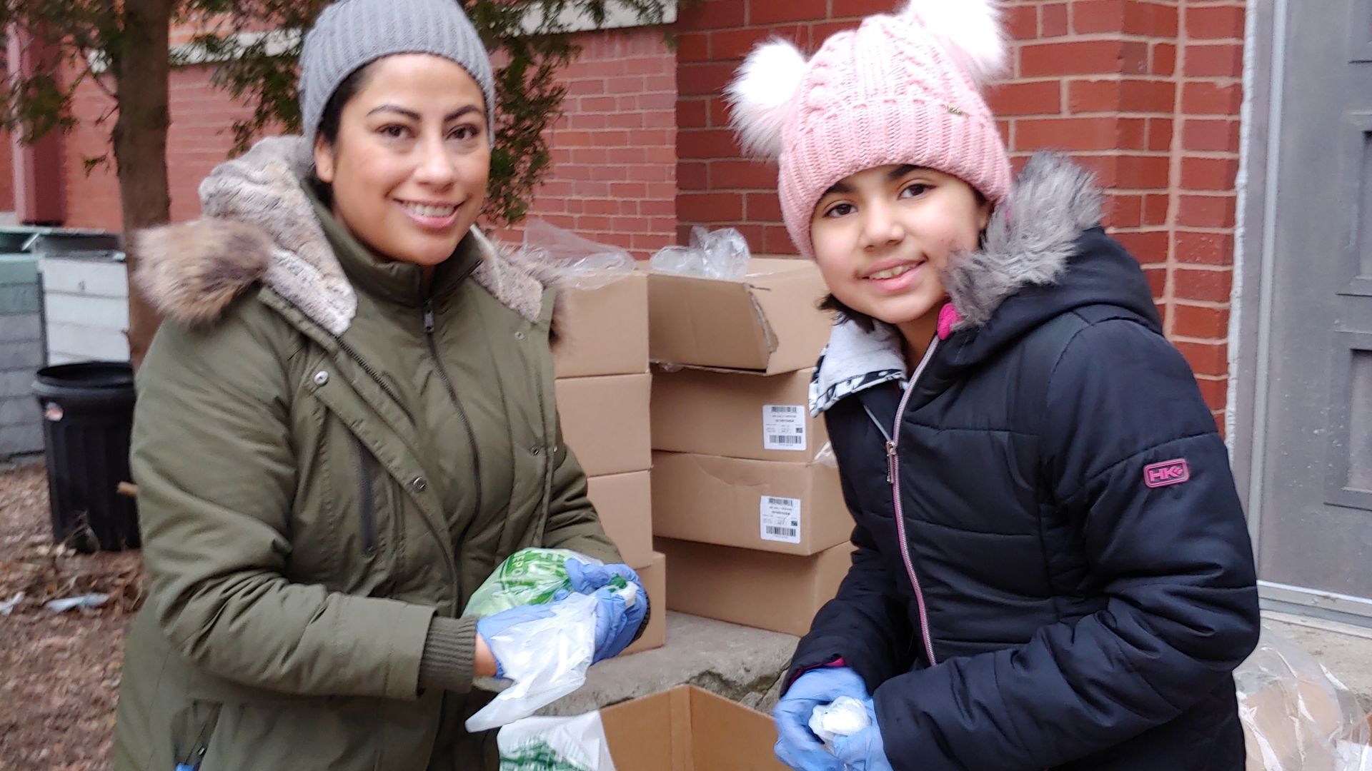 People packing a box for food pantries.