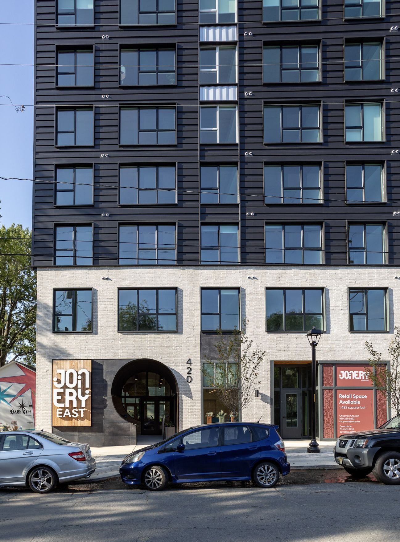 Front of apartment building with cars parked outside