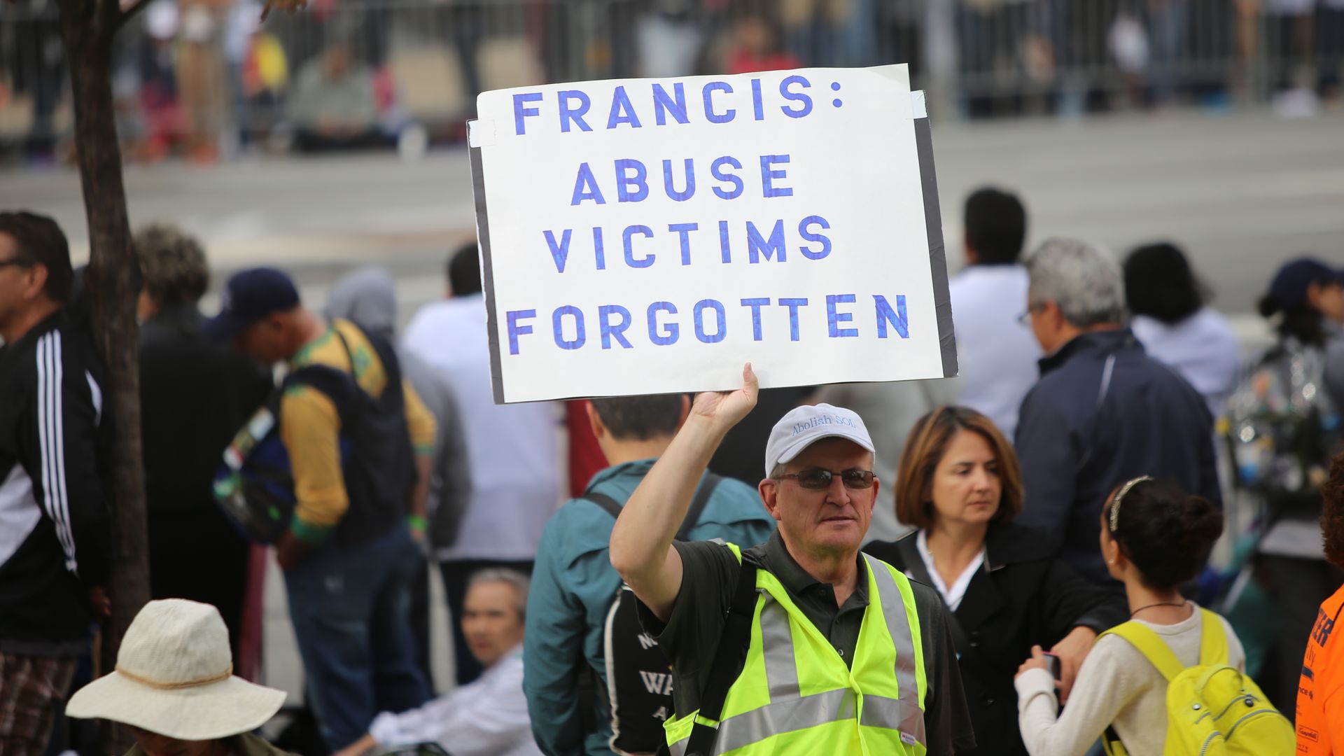 Man holding sign denouncing catholic church