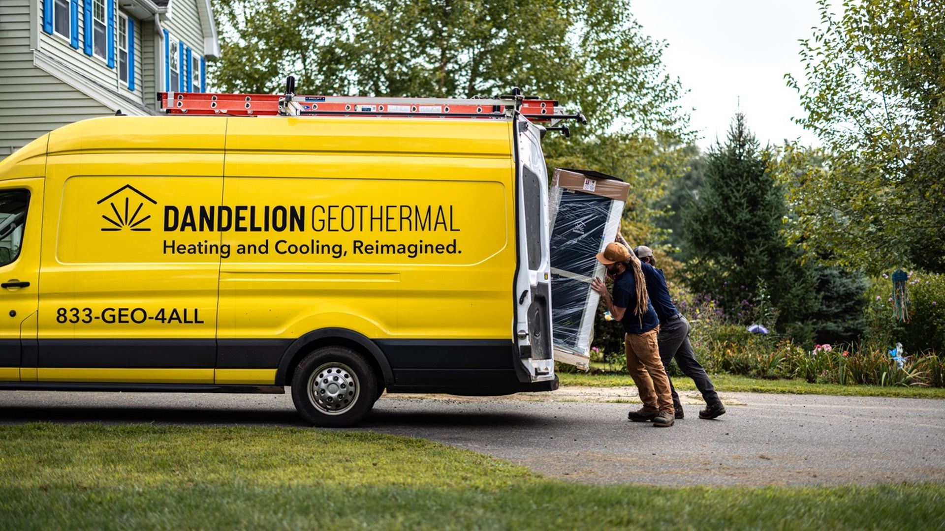 Workers for Dandelion Energy pull a geothermal heating and cooling system out of a van.