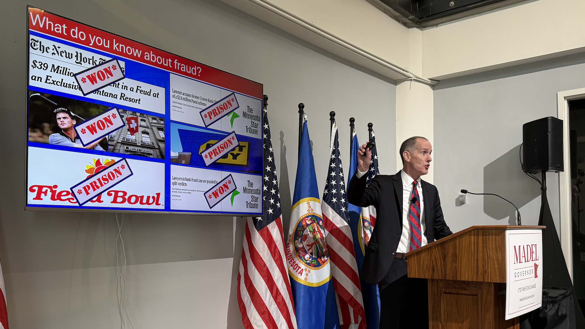 Chris Madel speaks at a podium with a power point showing headlines from cases he won